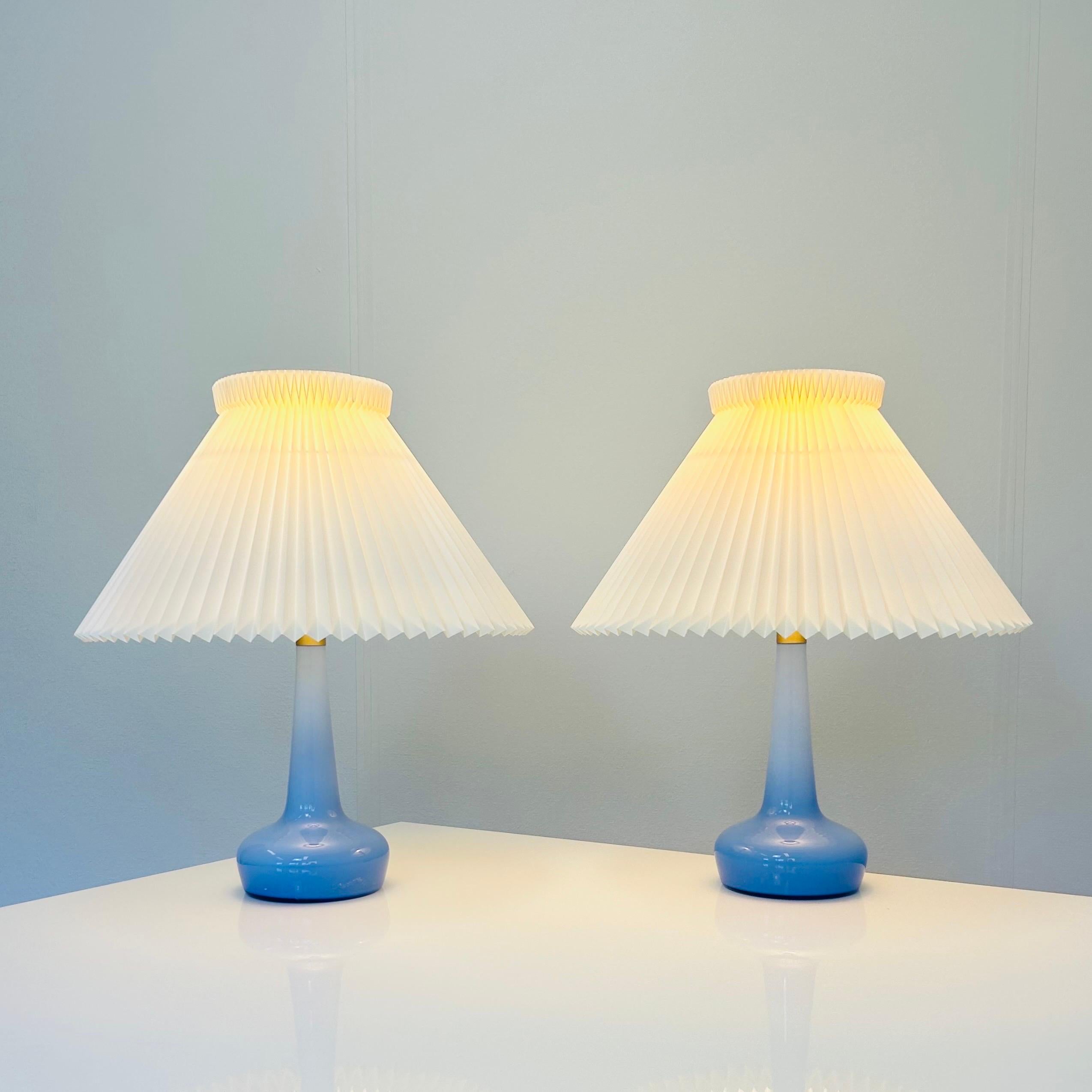 Paire d'exquises lampes de bureau en verre bleu conçues par Esben Klint pour Le Klint en 1949. Cet ensemble rare et captivant date des années 1980. Ces lampes ont résisté à l'épreuve du temps et sont dans un état vintage impeccable. D'une allure