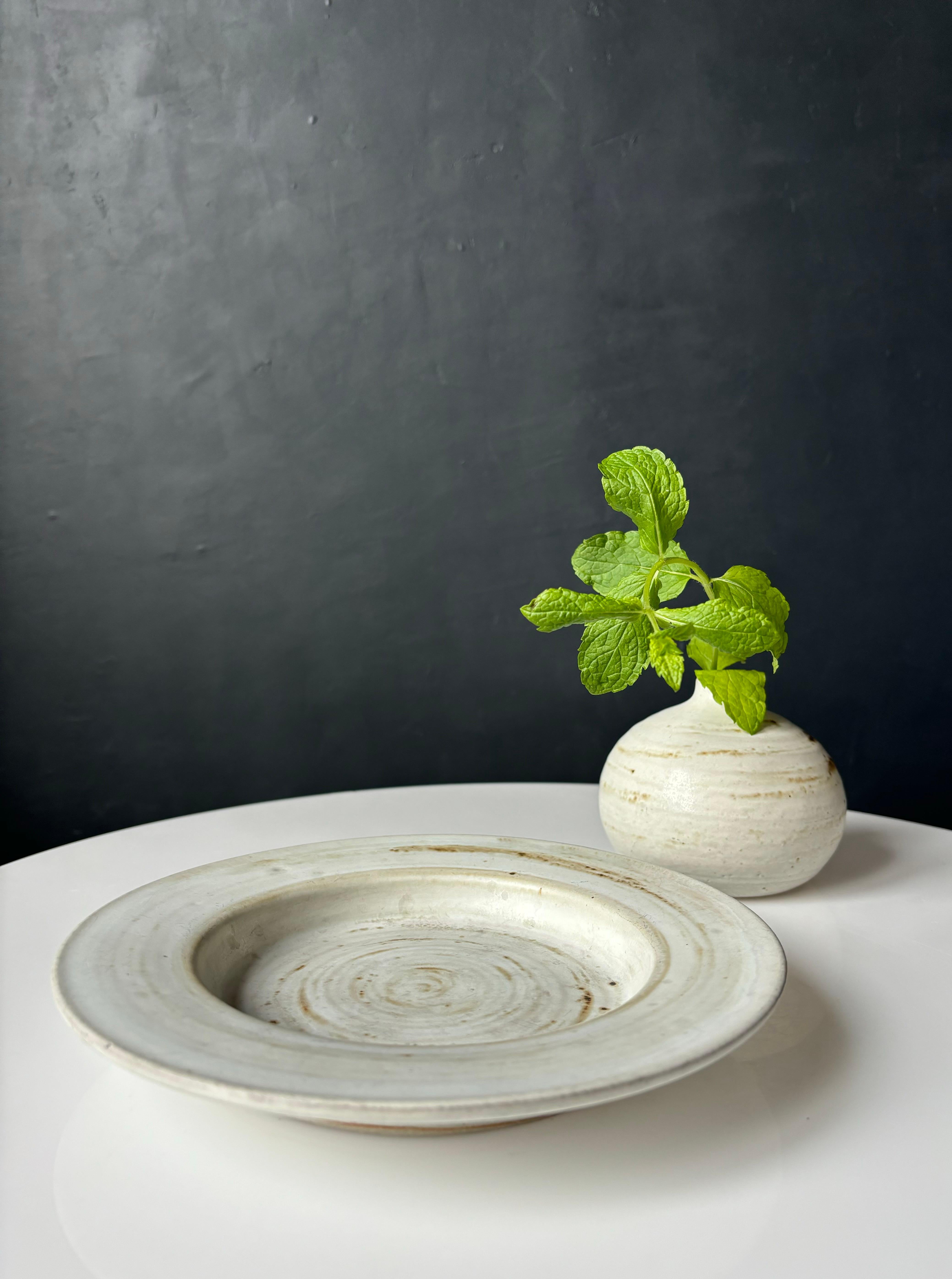Set di vasi circolari e di piatti vide-poche realizzati a mano in Danimarca, in stile midcentury modern. Look rustico con splendidi smalti nei colori grigio chiaro, bianco, sabbia e beige. Entrambi gli oggetti sono firmati dall'artista sotto la