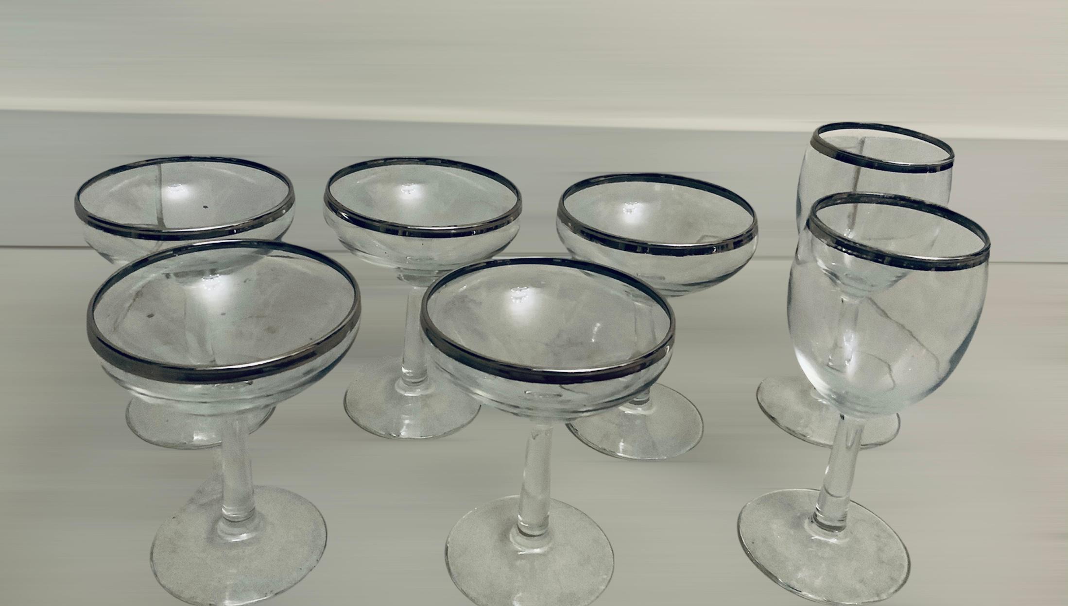 This is a set of Mid Century silver rimmed style clear glasses. It consists of different kind of barware glasses. This include four goblets (Ht-4.25”), five tumblers (Ht-4.25”), six “Roly Poly” medium (Ht-3.25”), four “Roly Poly” small (Ht-2.4”)