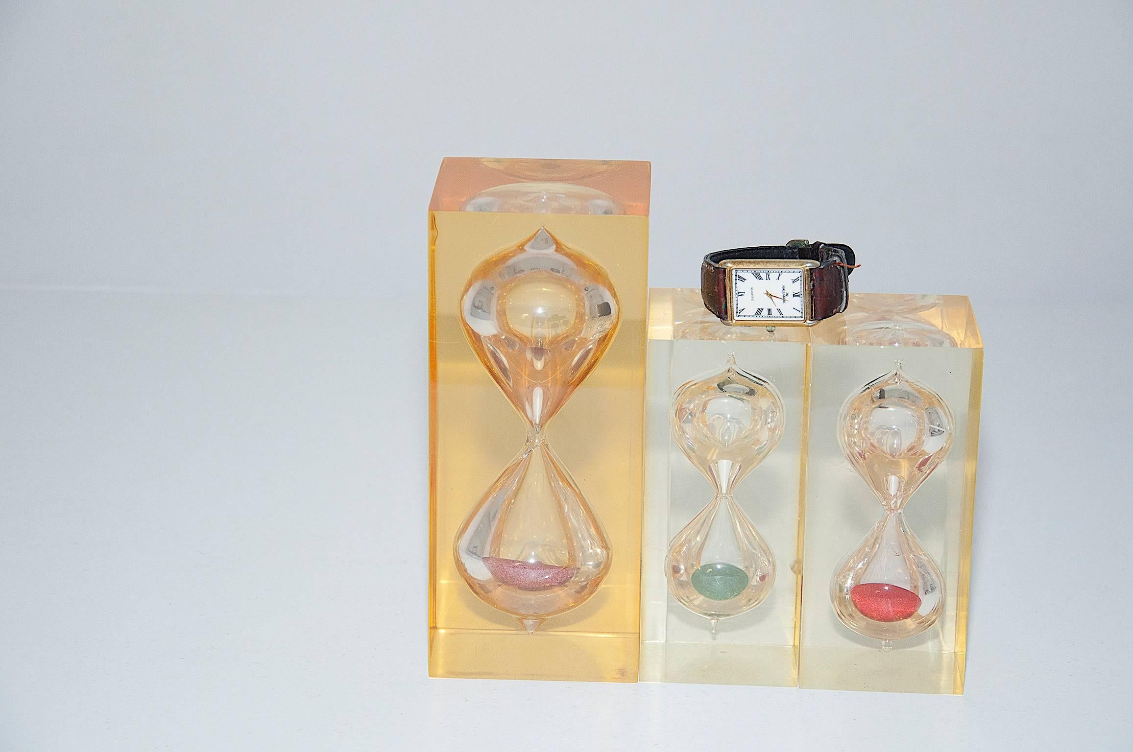 The set is composed of three resin sculptures with an HourGlass inside. The French artist Pierre Giraudon, probably did it in the period 1970-1980.
The biggest is 20 cm high and the two others 14cm high.
One is in orange-yellow colors, the others