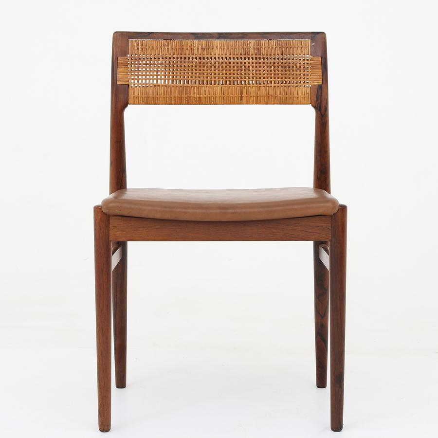 Set of six dining chairs in rosewood. Seat in patinated brown leather and back in woven cane. Maker Wørts Møbelsnedkeri.