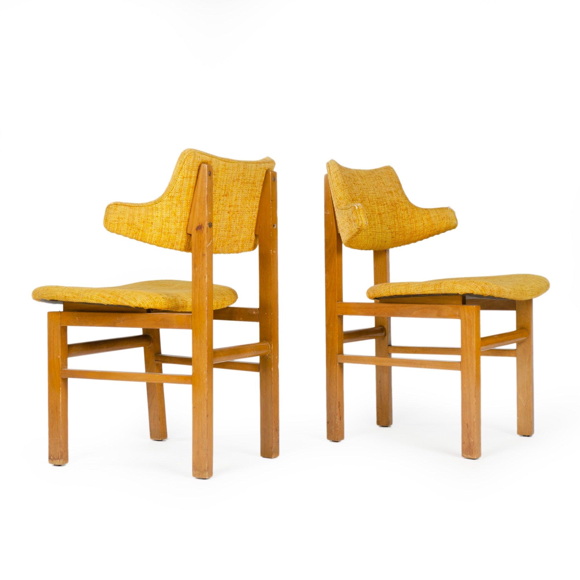 Un set di sedie da pranzo con struttura in noce a vista che sostiene sedute fluttuanti in laminato e schienali scultorei, entrambi rivestiti con tappezzeria vintage. Progettata nel 1953 come componente del nuovo Gruppo Carriera e prodotta fino al