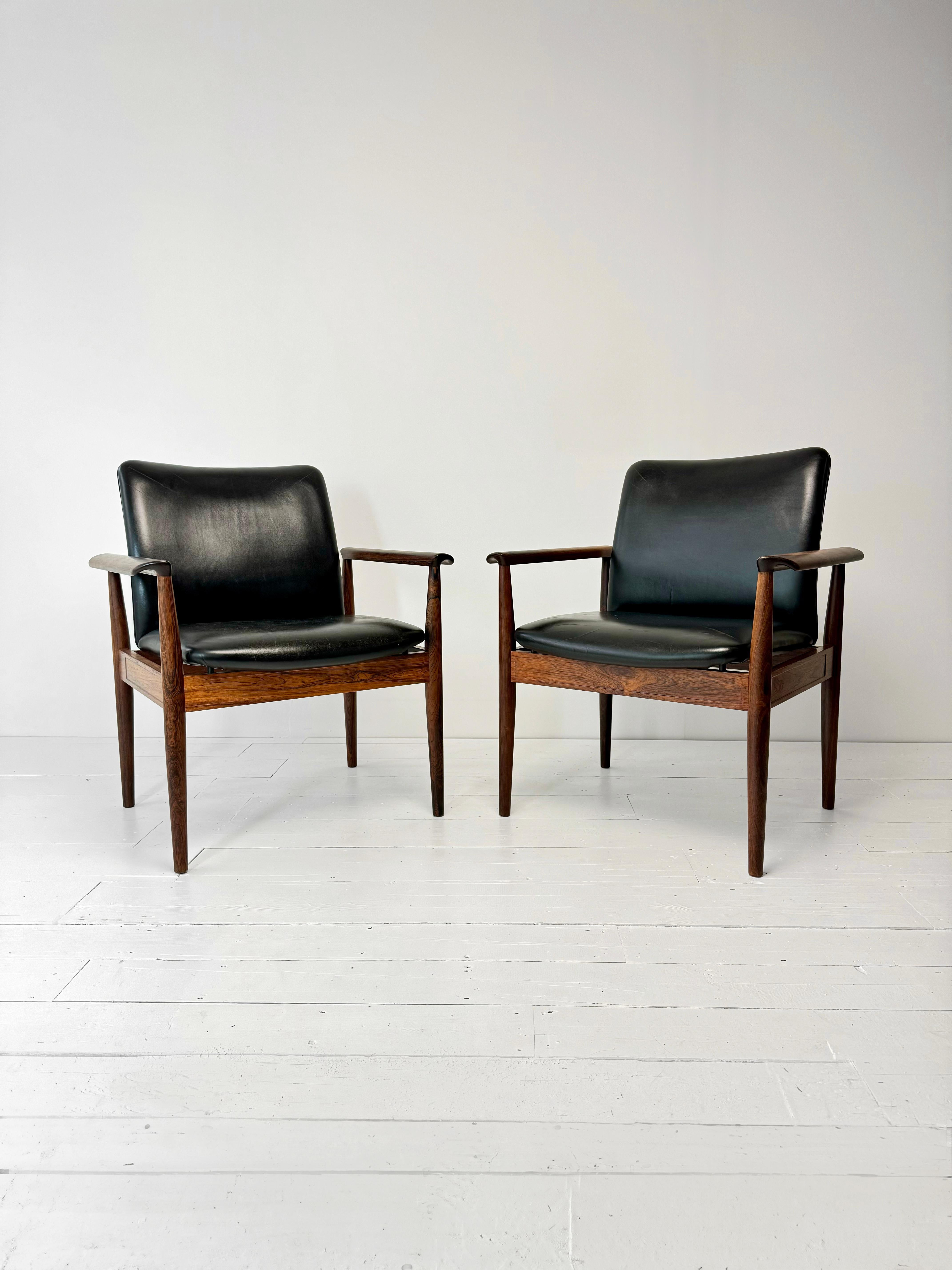 The Diplomat Armchair in Rosewood and Black Leather, designed by the iconic Danish designer Finn Juhl for France and Sons renowned Danish furniture makers of the 1960's, is a rare and important Mid Century Modern piece were originally made to