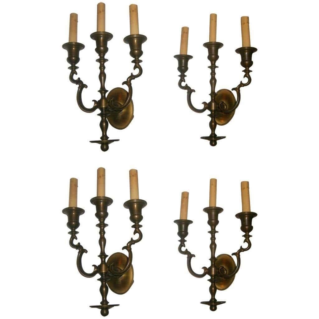 Set of four Dutch circa 1920's patinated bronze, three-light bronze sconces with oval backplate and original patina. Priced in pairs. Sold in pairs.

Measurements:
Height: 16.5