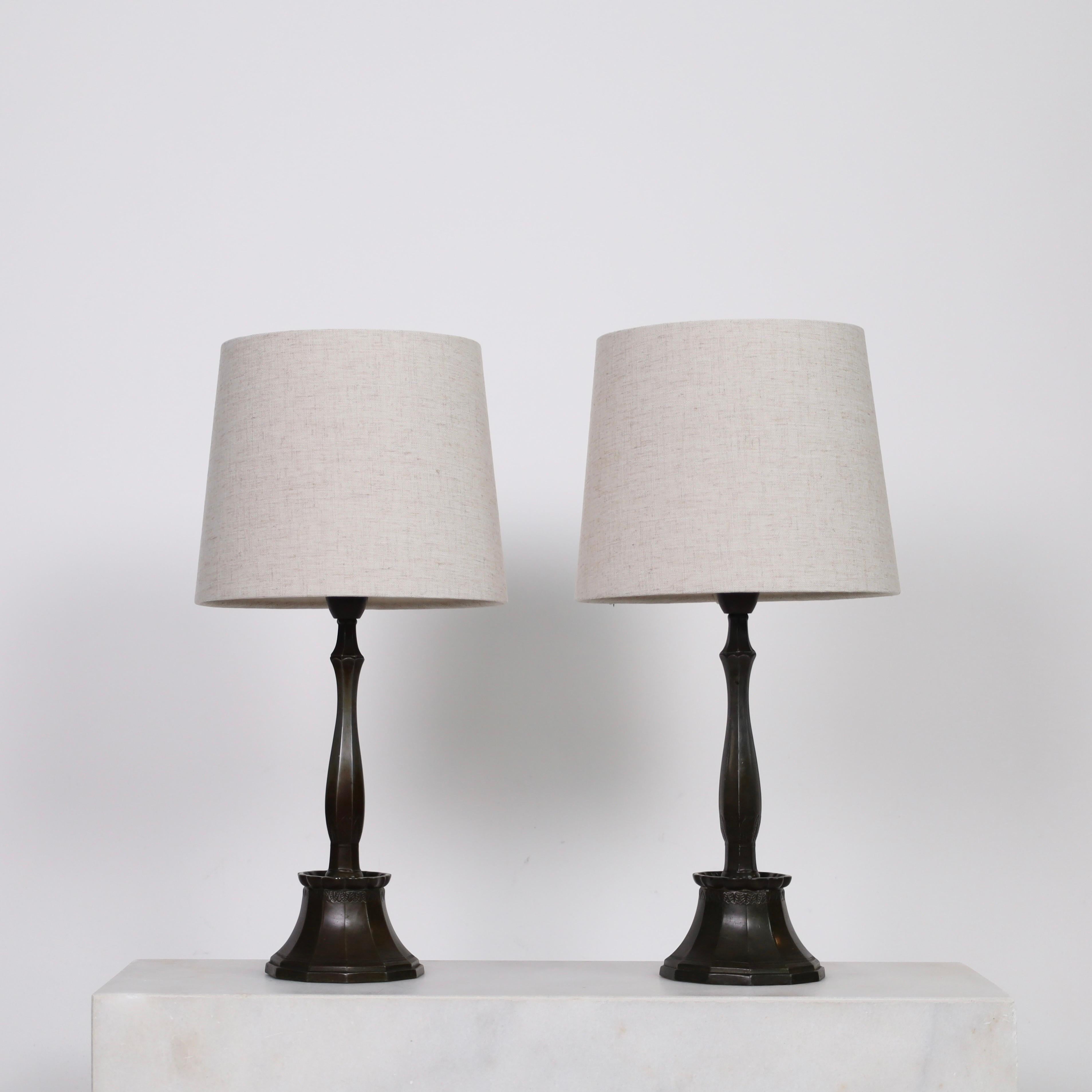 Ensemble de lampes de table Early-Work réalisées par Just Andersen dans les années 1920. Un duo exquis pour une belle maison.

* Une paire (2) de lampes en métal avec des bases à 12 côtés avec des ornements et des abat-jours en tissu beige.
*