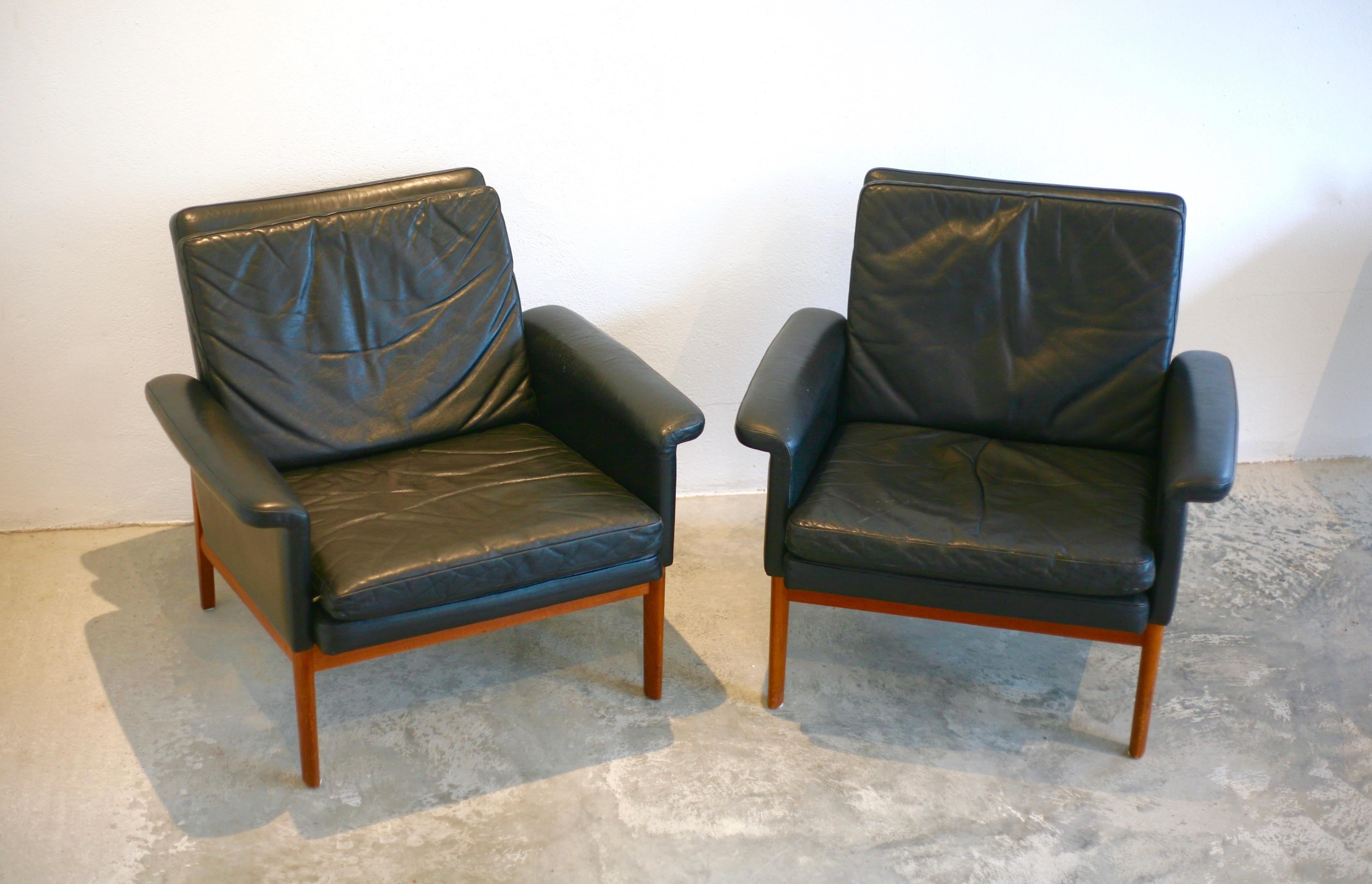 Two black leather armchairs from the series Jupiter, designed by Finn Juhl in 1962 for France and Son. Teak frame. Over all good vintage condition. Leather crazing on one arm rest.