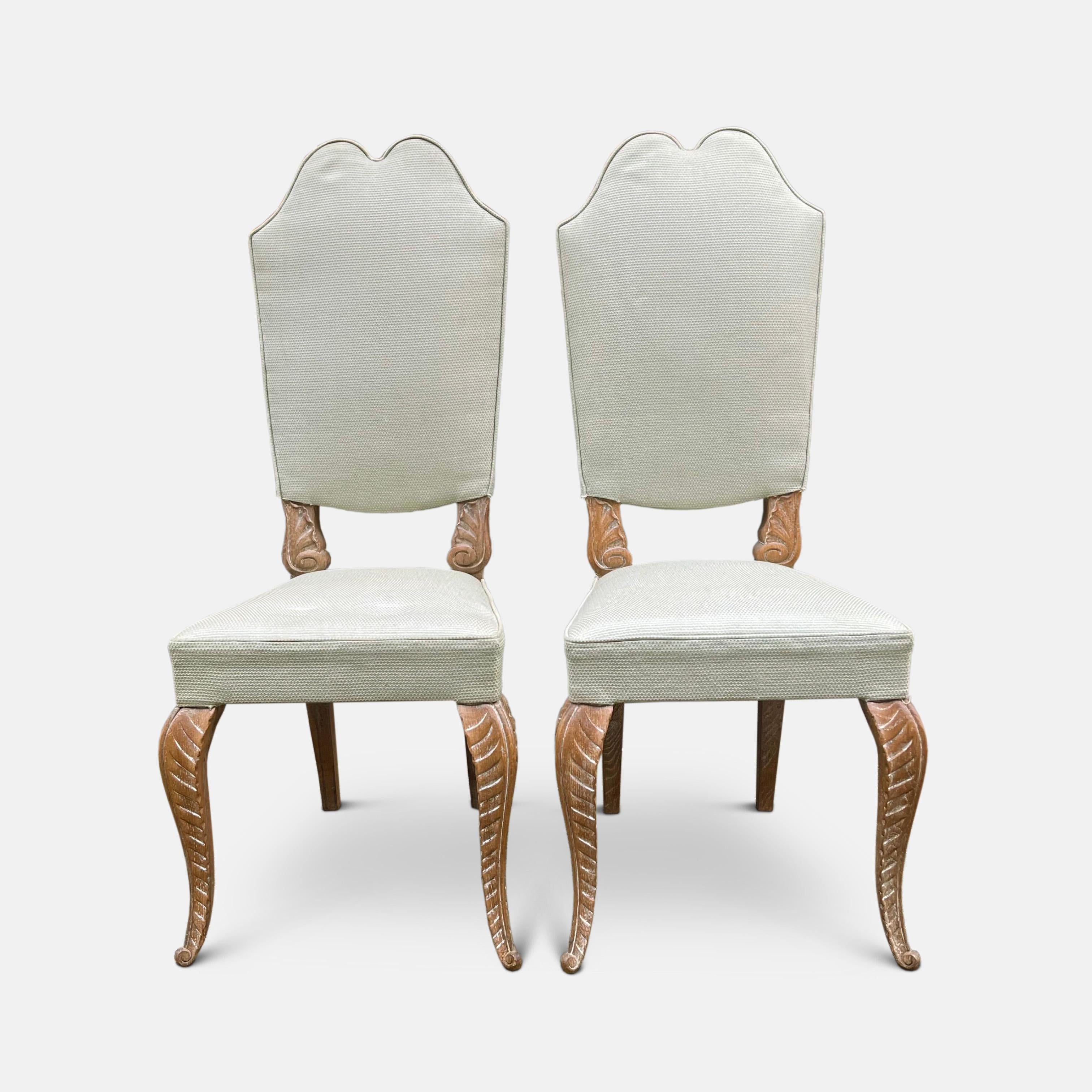 A set of eight 1940s limed oak dining chairs by Maison Jansen with high straight backs, shaped wonderfully at the top with the flourish of a double curved arch. The lower frame of each back is carved with acanthus leaves, along with the long,