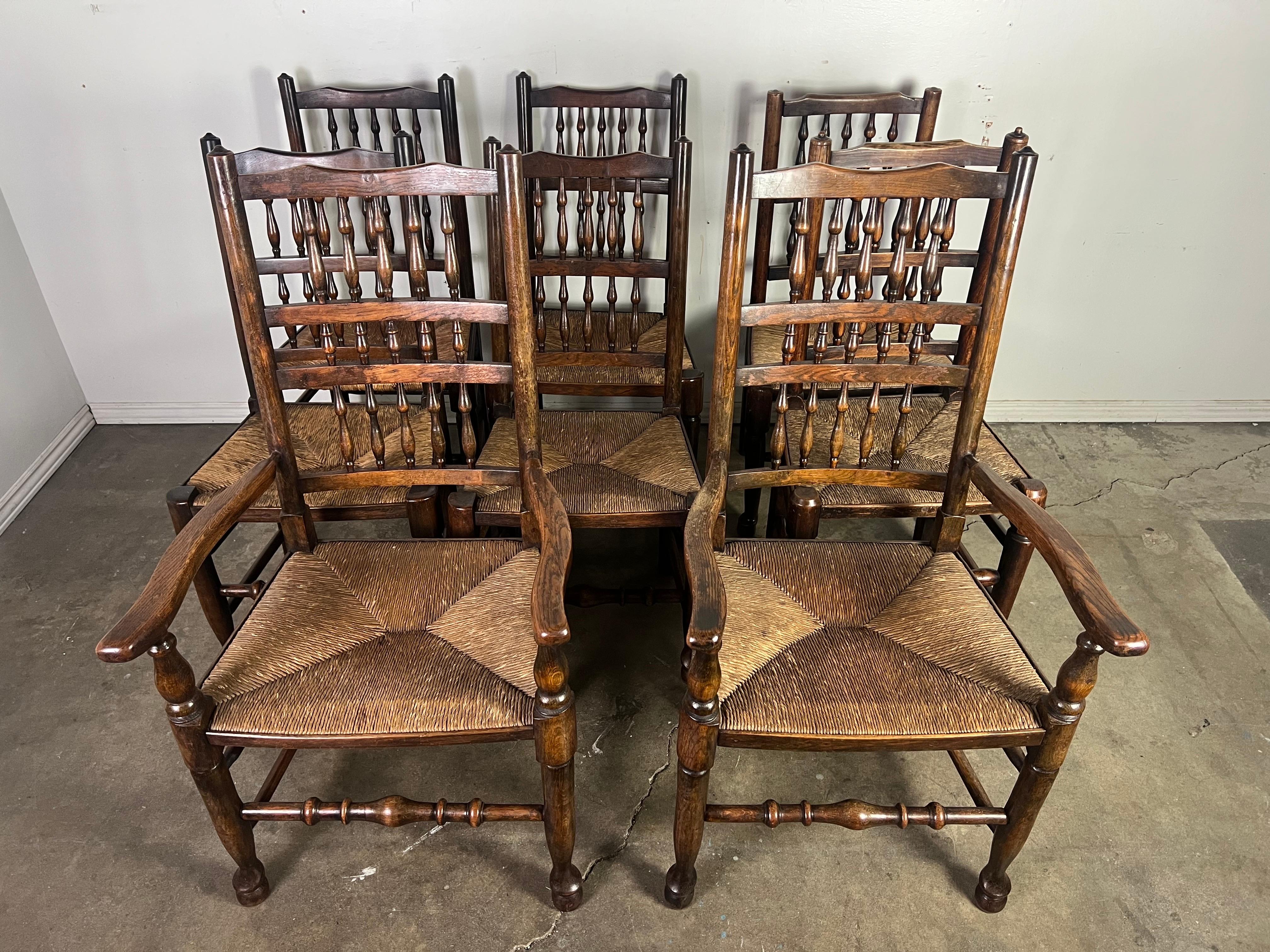 Ensemble de huit chaises de salle à manger traditionnelles anglaises du 19e siècle.  Ces chaises ont un style rustique avec une finition en bois foncé.  Les chaises présentent de hauts dossiers en échelle ornés de fuseaux tournés, ajoutant une