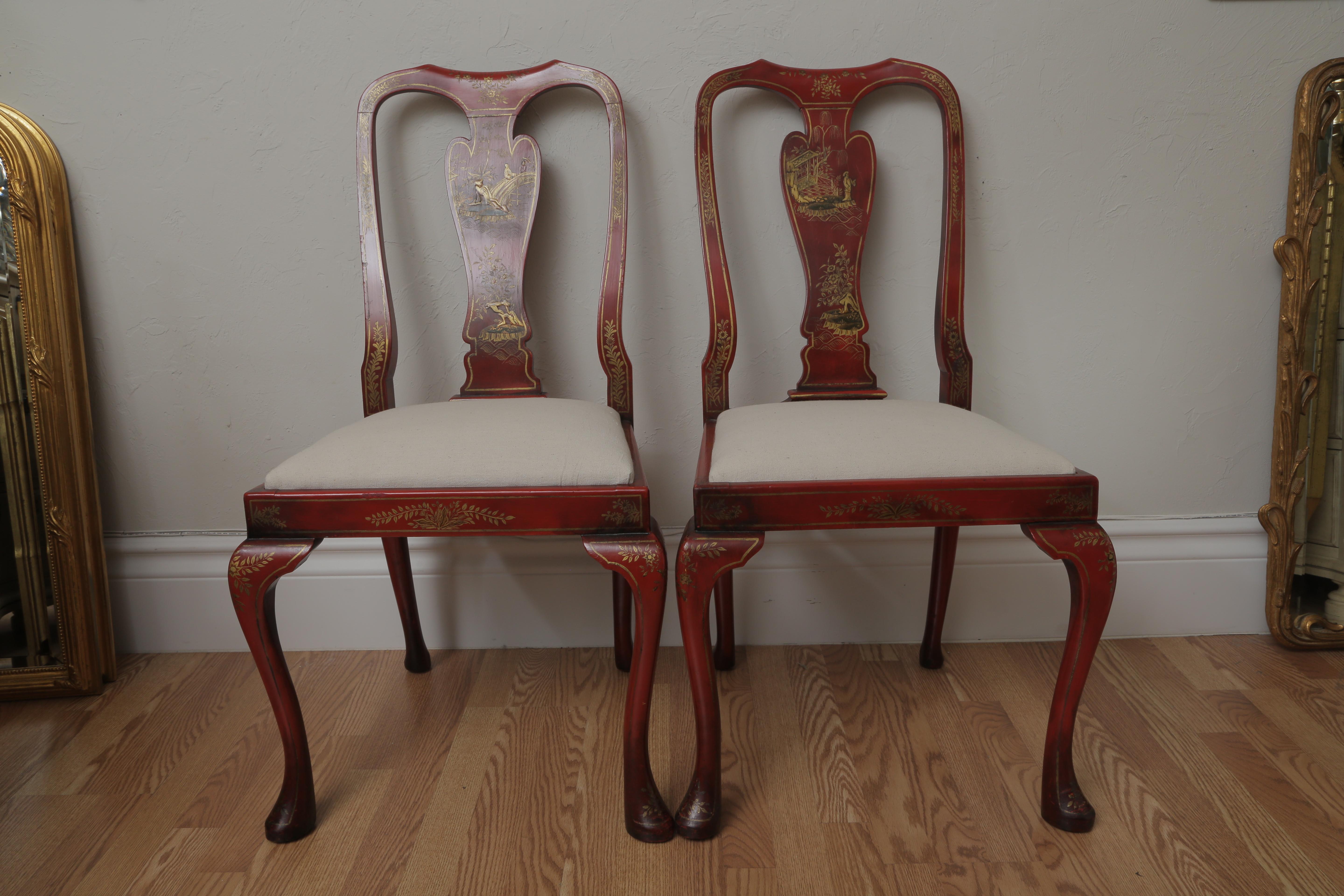 Wonderful set of eight red chinoiserie dining chairs consisting of two armchairs & six sides. Newly upholstered seat cushions. Each back splay is hand painted in a different scene. Very stable and good condition. An extraordinary fine set of chairs.