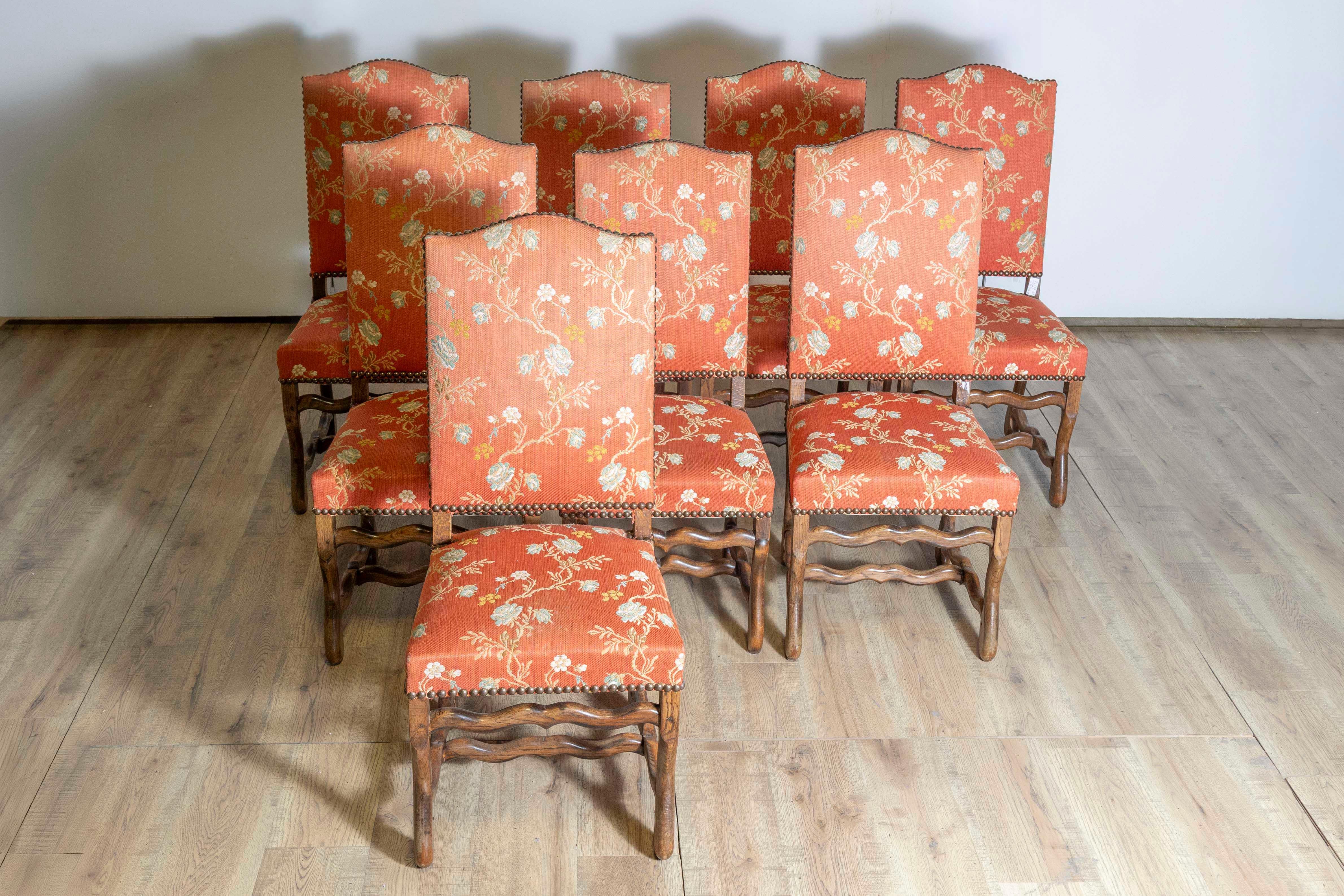 This set of eight 20th-century French mutton-leg side chairs exemplifies the timeless elegance of traditional French craftsmanship. The chairs feature sturdy wooden frames with gracefully carved mutton-leg (os de mouton) legs, a design element