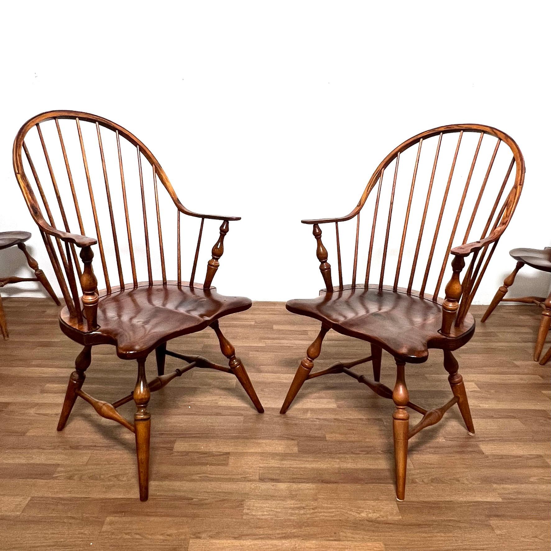 A set of eight handmade artisanal Windsor dining chairs, consisting of six balloon back side chairs and two continuous arm chairs with turned legs and saddle seats.  Purchased by prior owner at the Walker Creek Woodshop in Essex, MA, in the 1980s. 