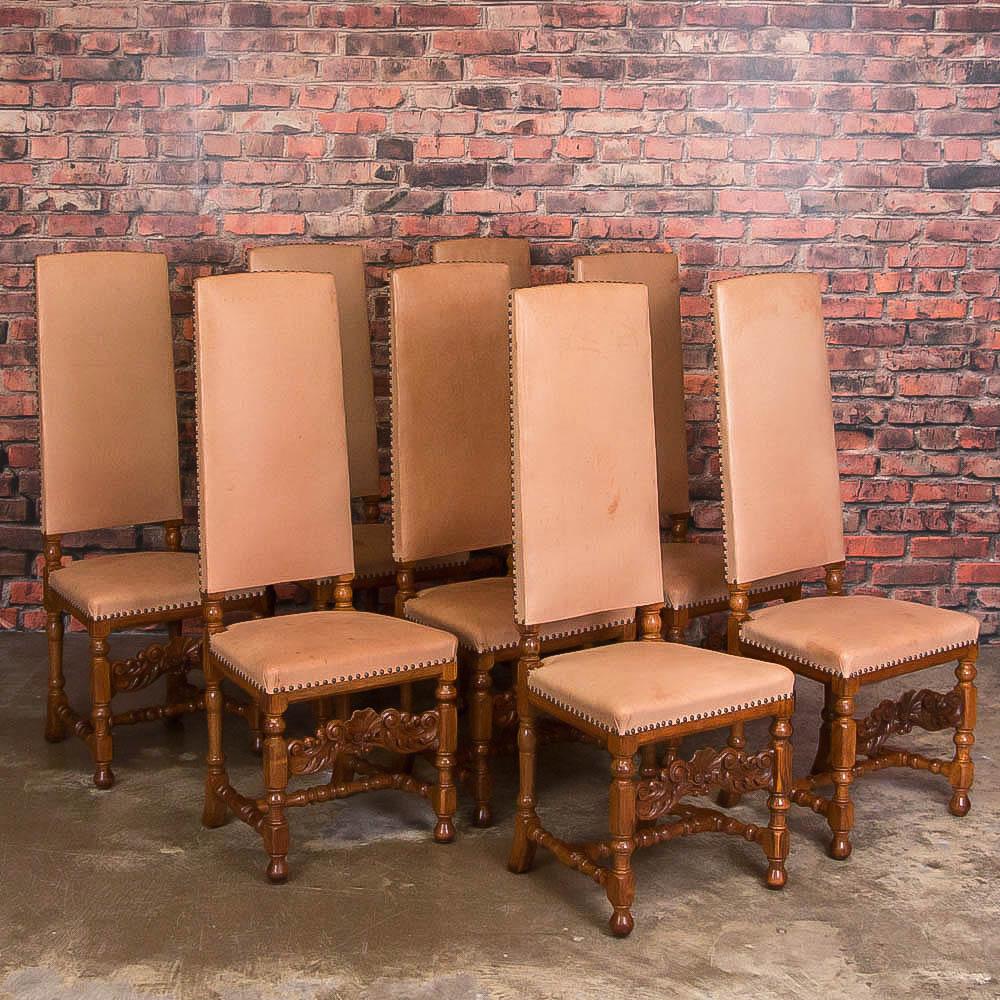 The dramatic high backs create a distinctive statement in this set of 8 dining chairs. The baroque carved details of the oak base also add to their style. You may choose to keep the vintage leather or add new upholstery for an updated look. The