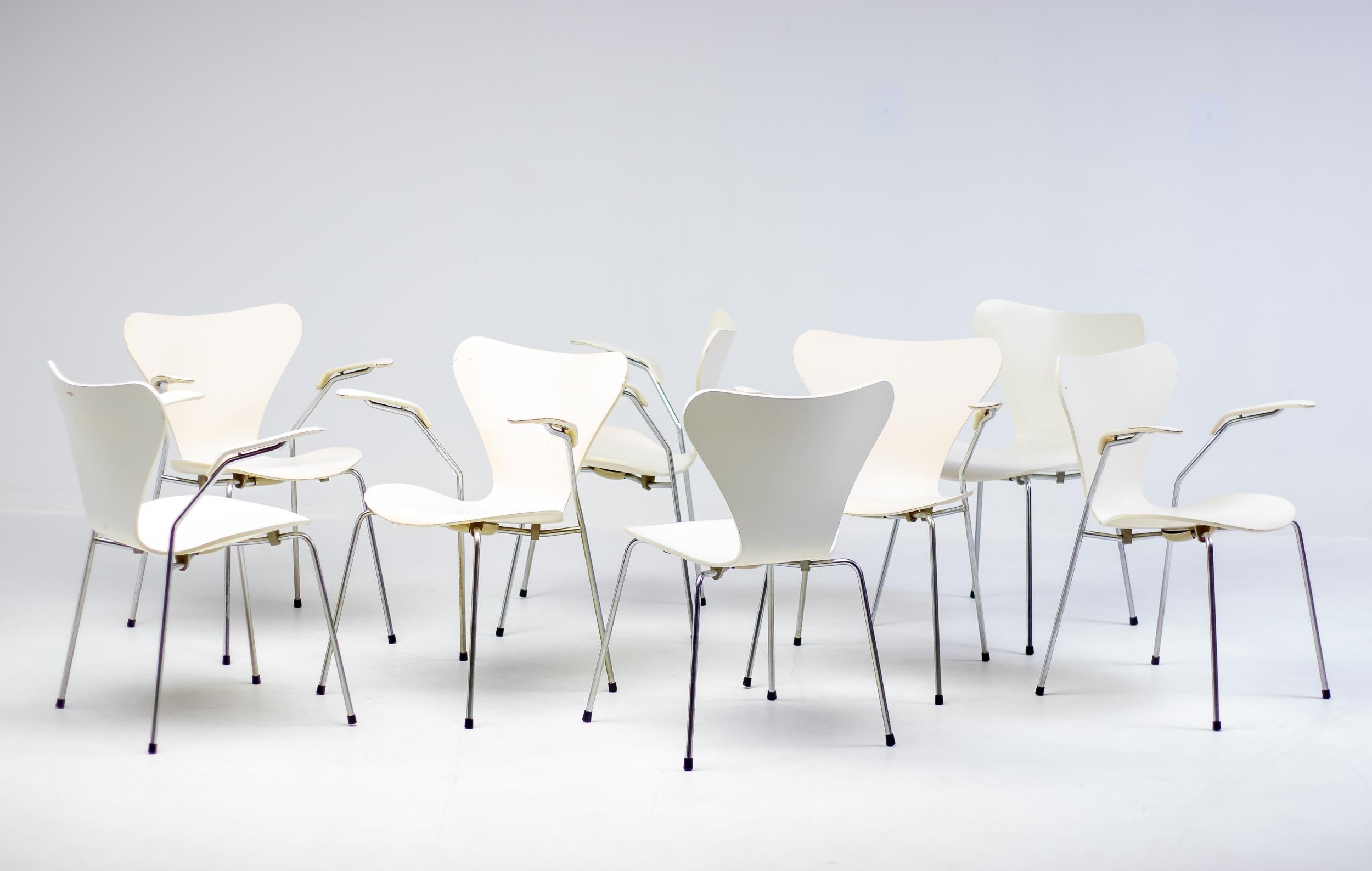 Matching set of 6 arm chairs model 3207 and 2 side chairs model 3107 designed by Arne Jacobsen, produced by Fritz Hansen in Denmark in 1973. Cream colored lacquer with some wear as one would expect from a set of chairs after 50 years of careful