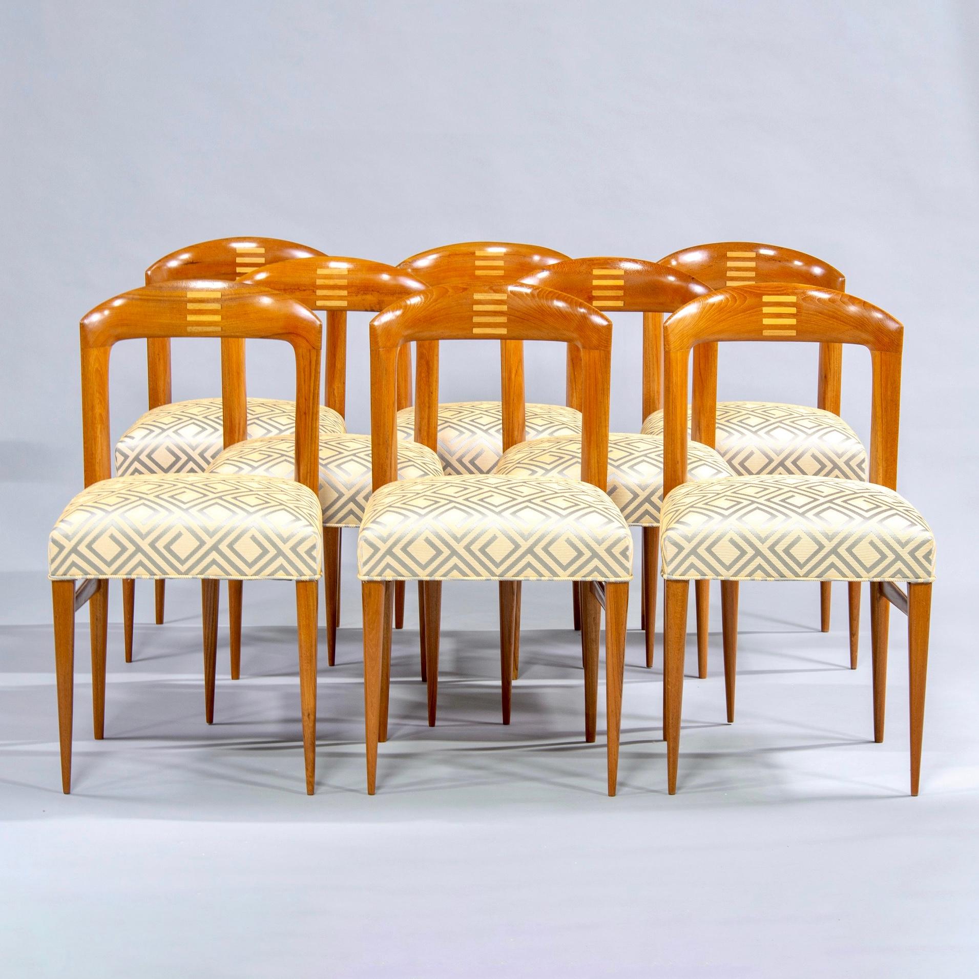 Set of eight polished Art Deco beech chairs, circa 1940. Open backs with curved tops feature inlaid design of stacked bars in contrasting blond wood. Slender, tapered legs. Professionally upholstered with new seats and designer fabric in pale gold