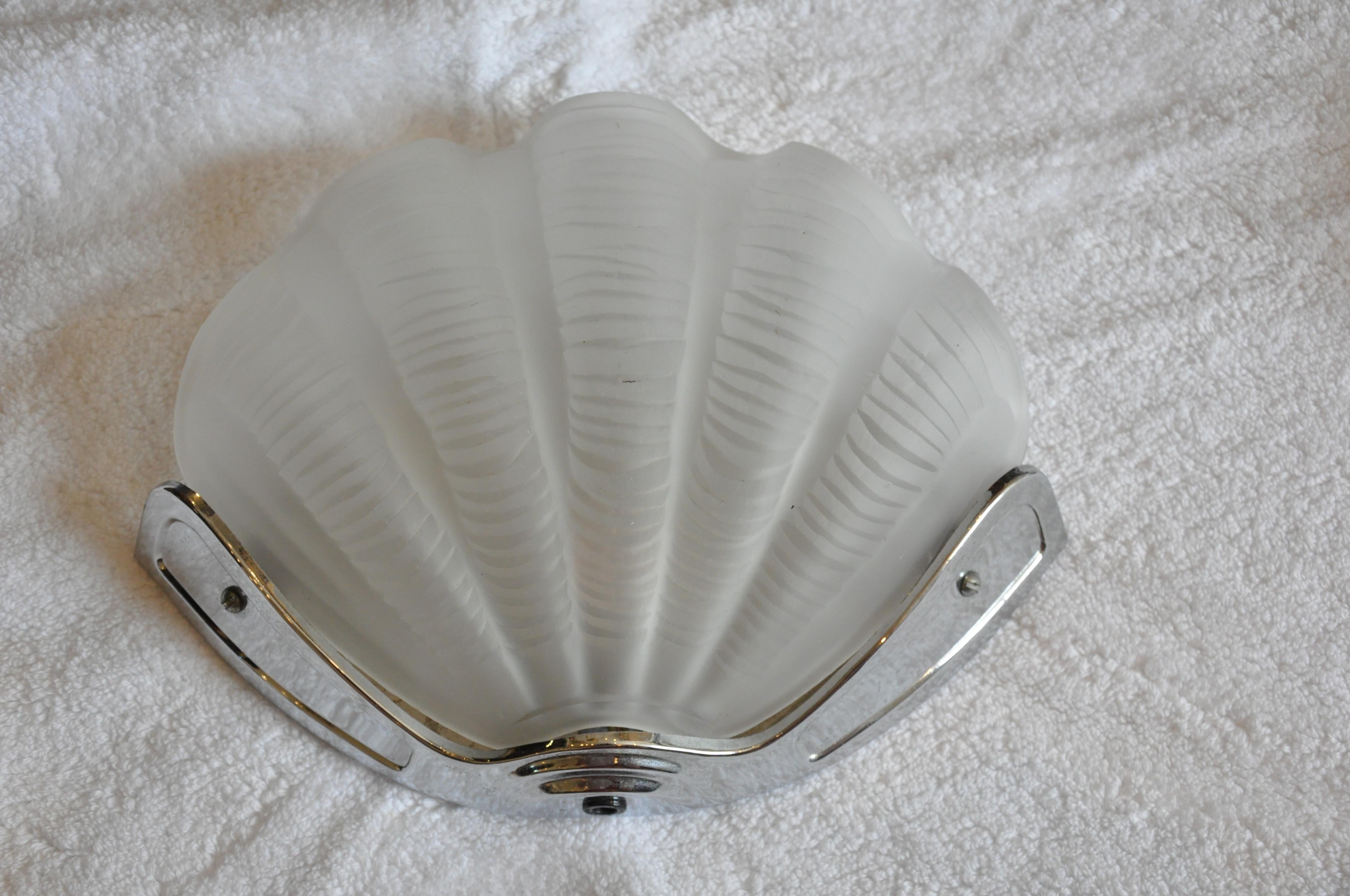 Eight Art Deco style sconces

Modeled as a realistic three dimensional frosted glass scallop shell, held by a chrome bracket support, wired for electricity.
Beautifully handcrafted and of good size and proportion.

Eight in total but we will