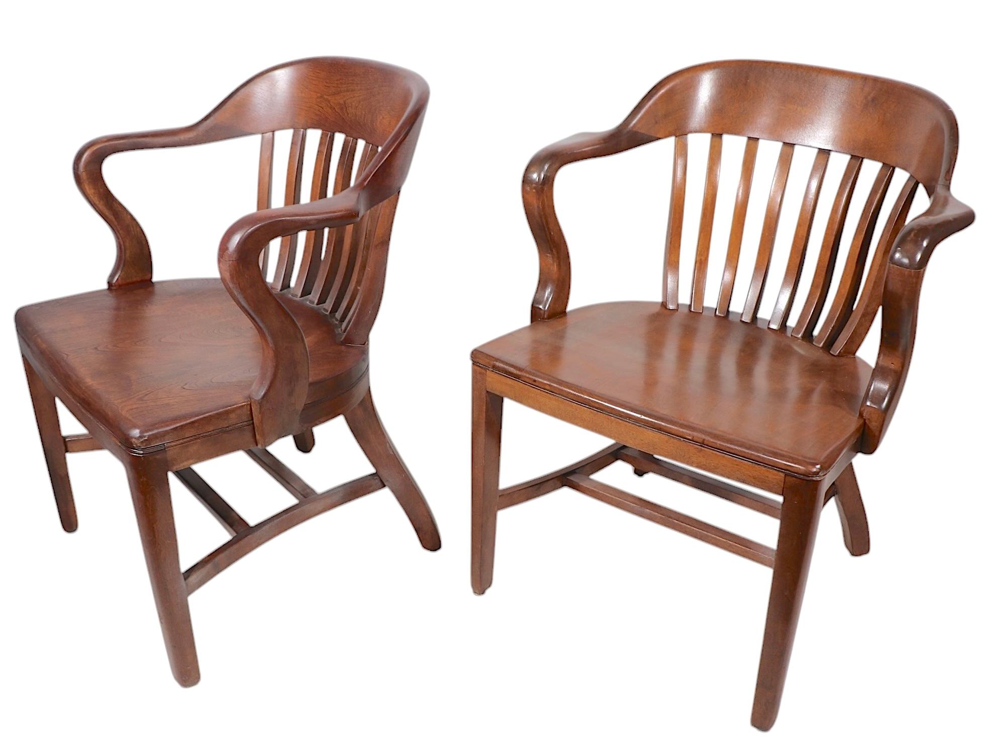 Rare set of eight matching Bank of England, Jury, Yale Library chairs, featuring a continuous arm, back rest, with spindle backs . The chairs are constructed of solid walnut, made by Sikes, circa mid 20th C.  All eight  are in solid, sturdy, clean