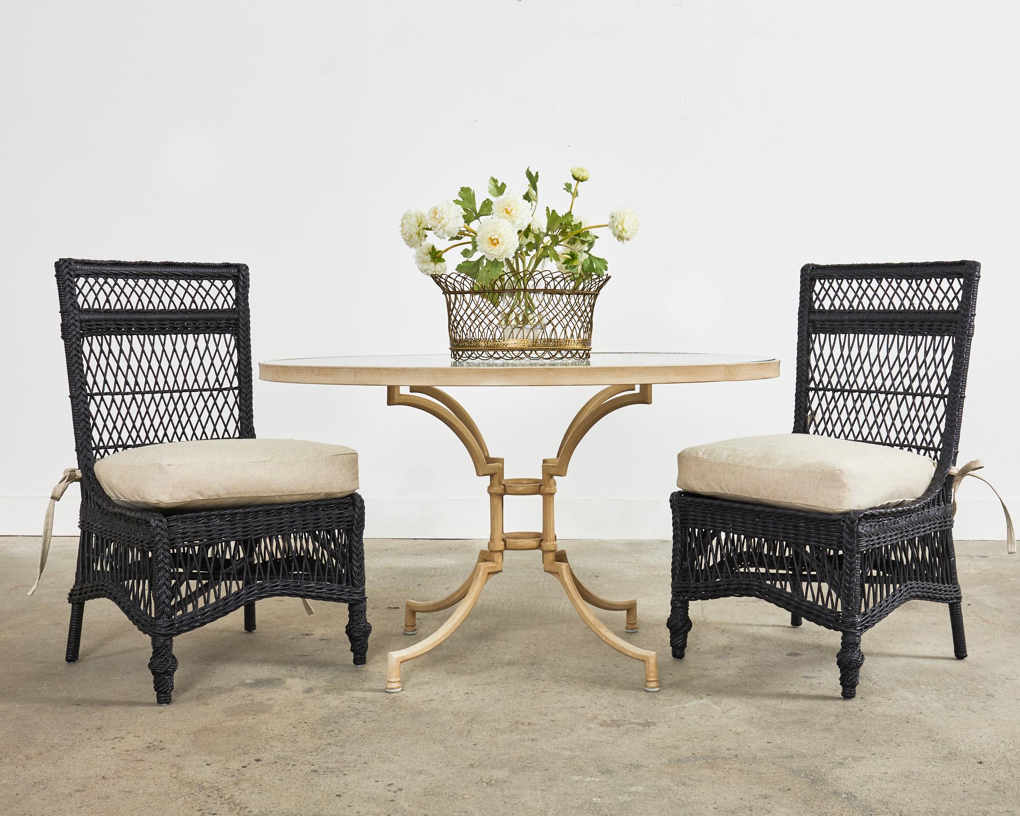 Gorgeous set of eight painted garden chairs or dining chairs made in the manner and style of Cyrus Wakefield Bar Harbor. The chairs are constructed from sturdy rattan frames with an open fretwork design of wicker. The chairs feature a tall square