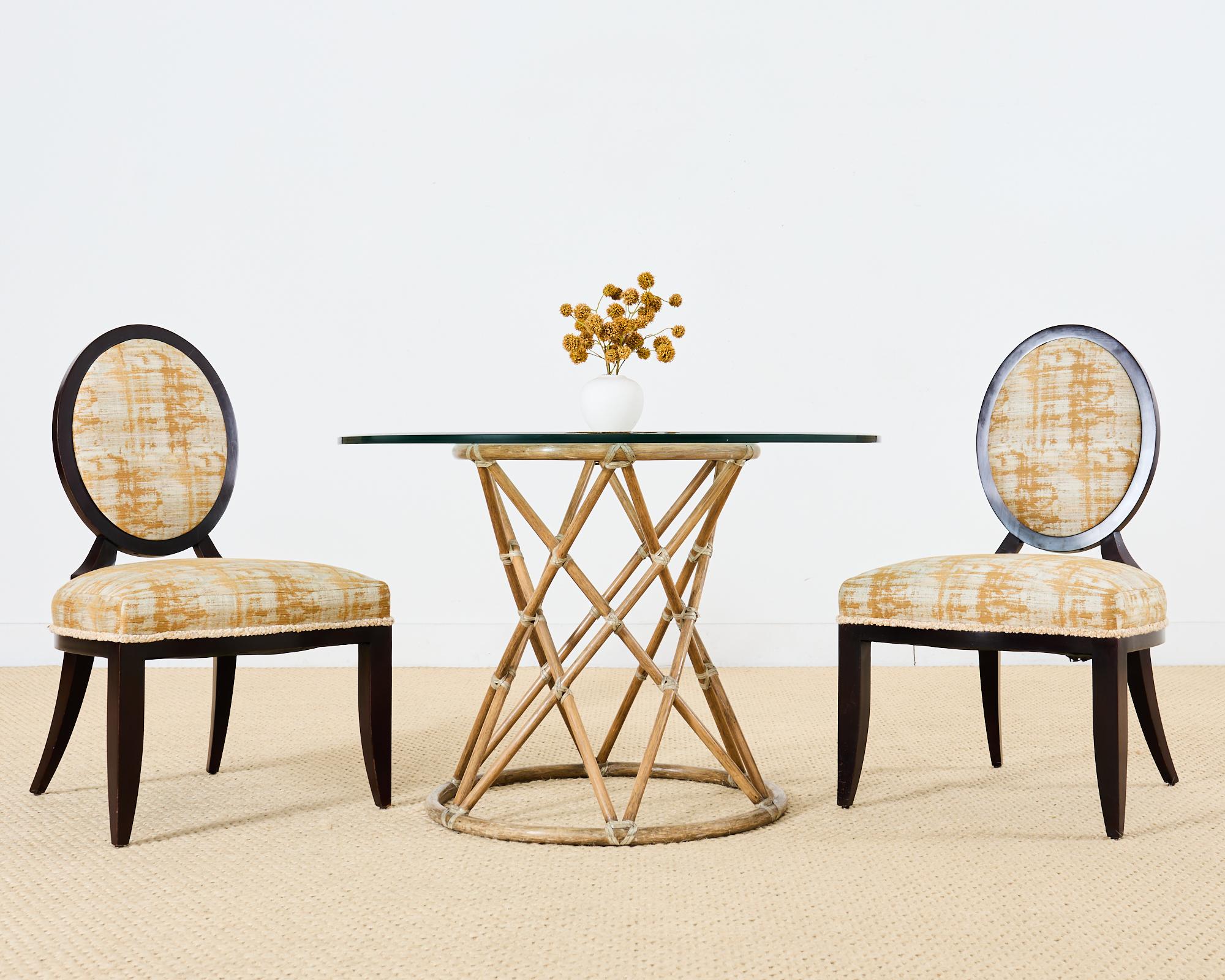 Dramatic set of eight Barbara Barry for Baker attributed dining chairs featuring Barry's iconic oval x-back. Constructed from beech hardwood with a dark near ebony finish the generous seat and round back showcase a gilt brocade style fabric with an