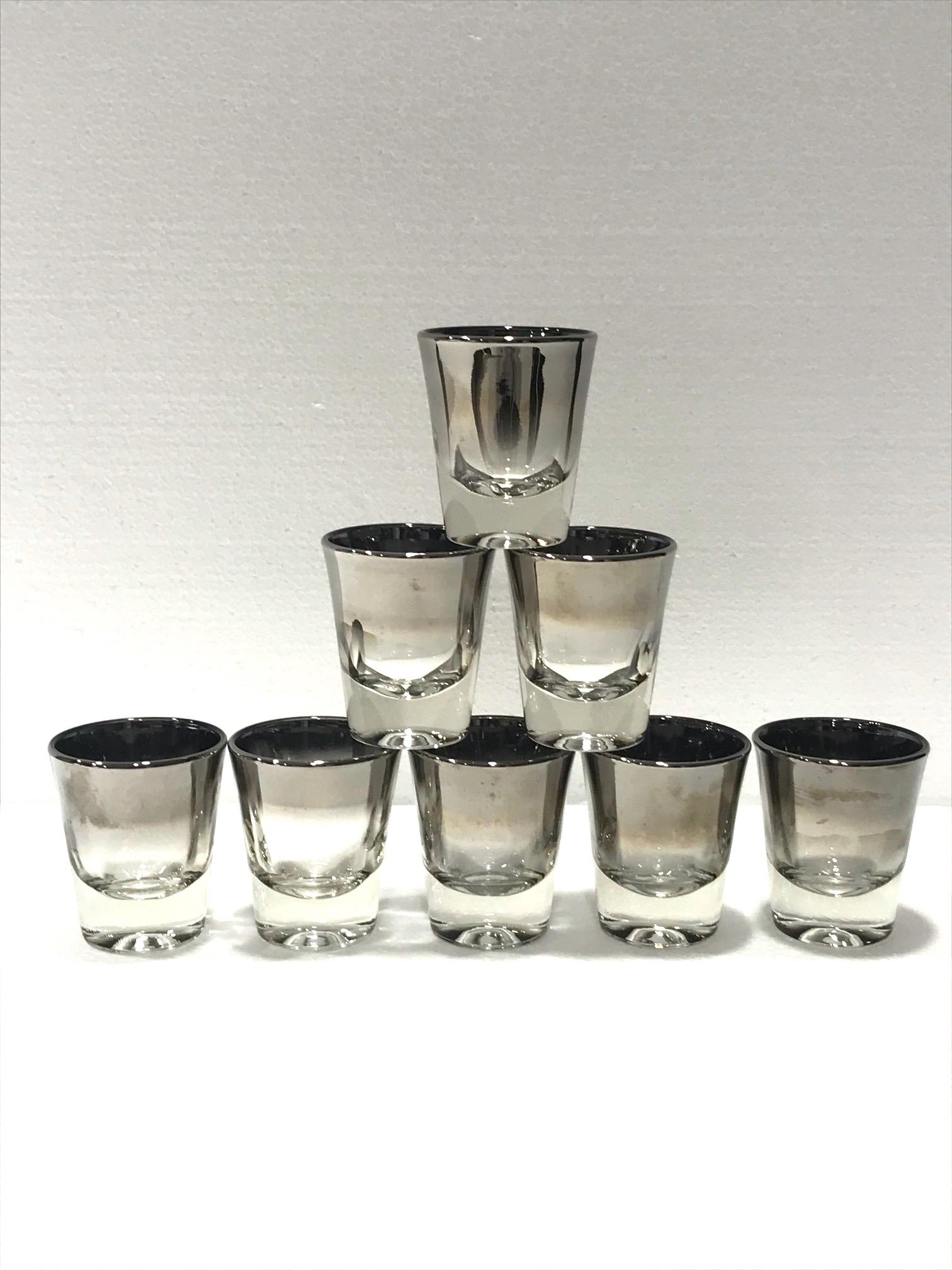 Iconic Mid-Century Modern barware shot glasses set with silver fade overlay design. Gorgeous shot glasses with tapered forms and gradient hues of gunmetal silver along the rims. Makes a chic addition to any barware set.

