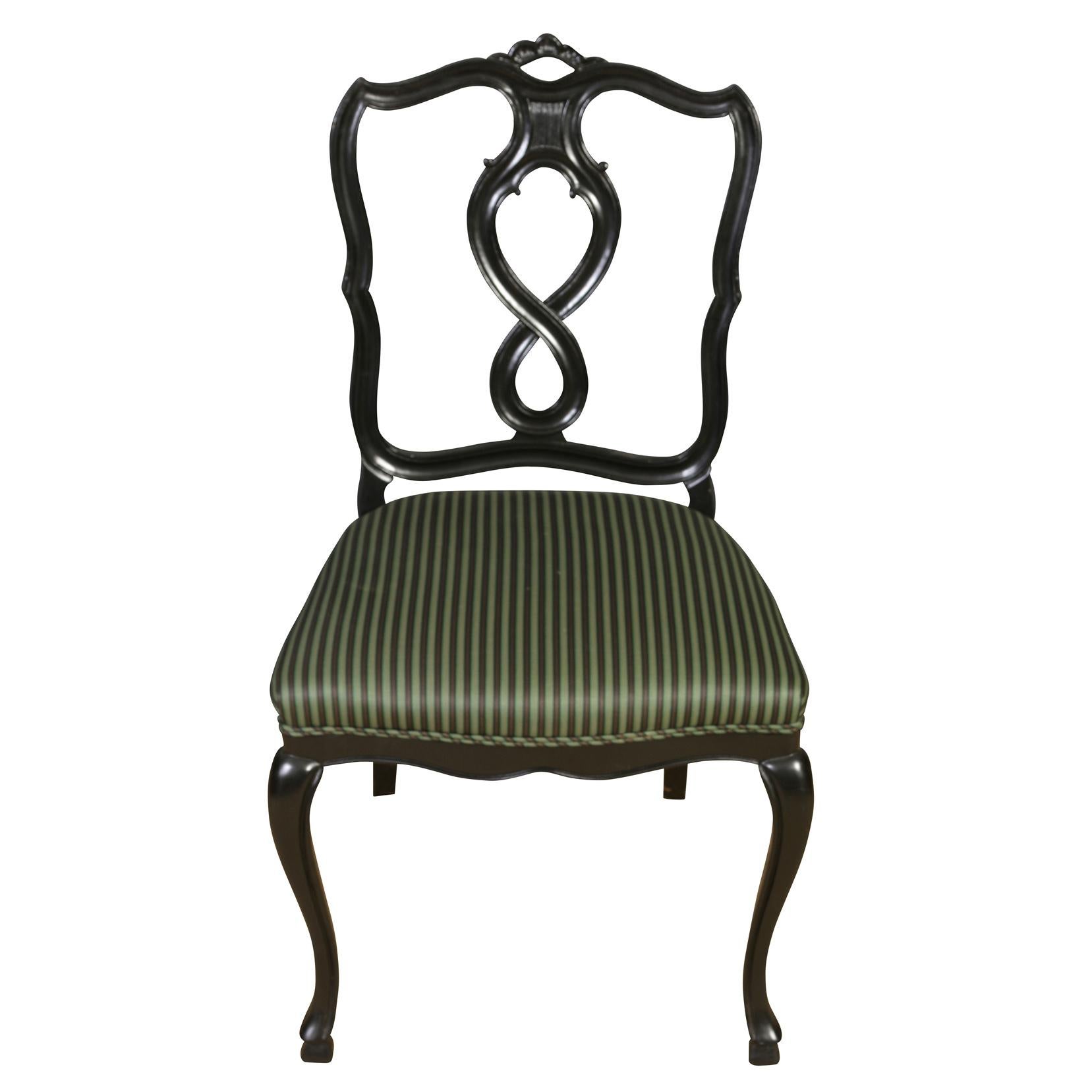 A vintage set of eight dining chairs with black laquered frames, cabriole front legs, a shield back with a curved design and figure eight center splat. Upholstered seats with striped fabric. Side chairs measure 21.5