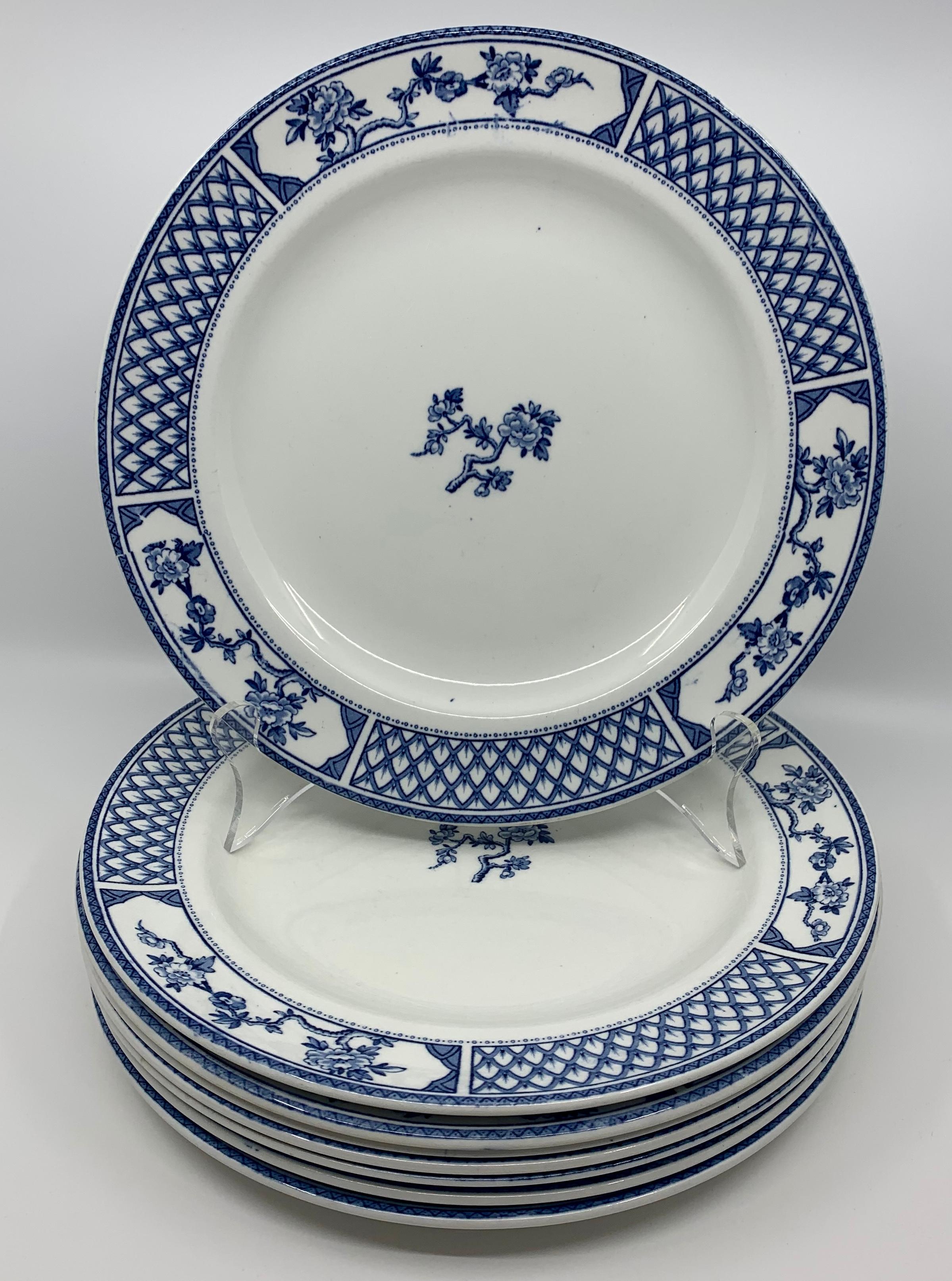 Set of eight of blue and white Exeter plates. Eight white English plates with blue lattice border in between floral reserves centering on one cherry blossom sprig. Classic and handsome blue and white plates. Markings 