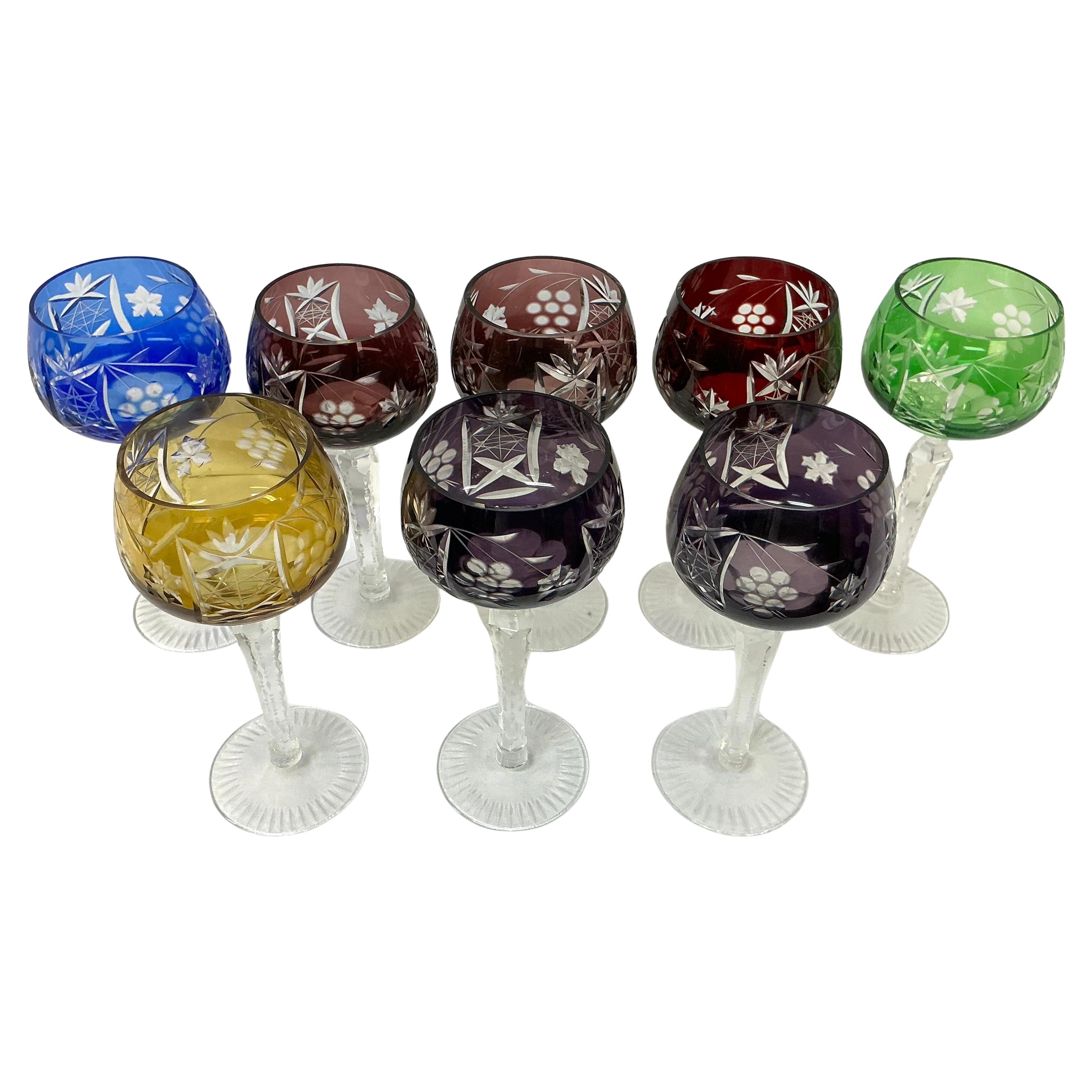 Set of Eight Bohemian Crystal Wine Glasses. Glasses are etched with grapes,  leaves, and starbursts. The clear crystal stems are notched and the bases have starburst motif. The color schemes are Cobalt Blue(1), Emerald Green(1), Amber Yellow(1), and