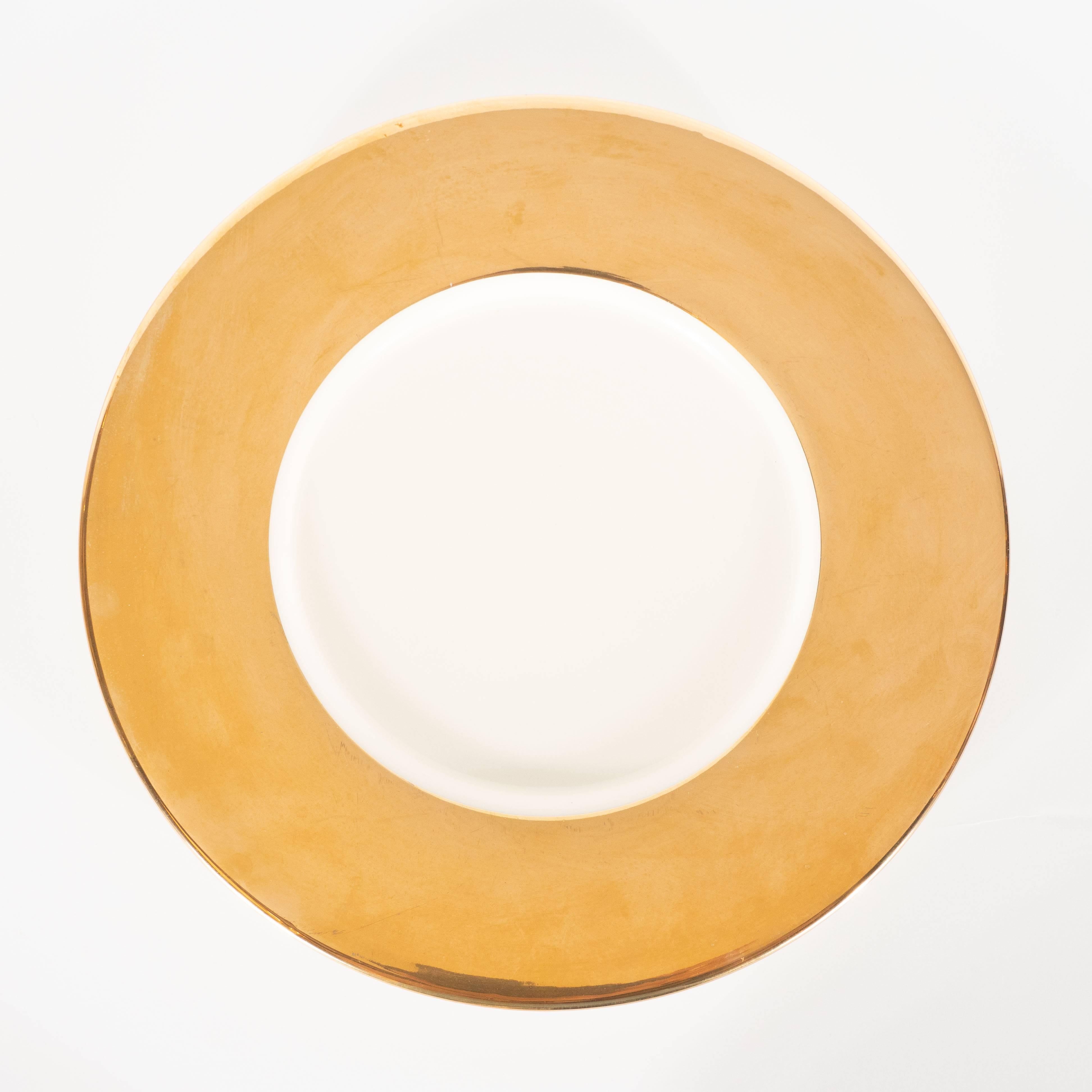 These stunning charger plates were realized by the esteemed American producer, Lenox, circa 1980. They offer porcelain centres in a rich bone surrounded by 24-karat yellow gold. Founded in 1889, by Walter Scott Lenox, the brand has pursued their