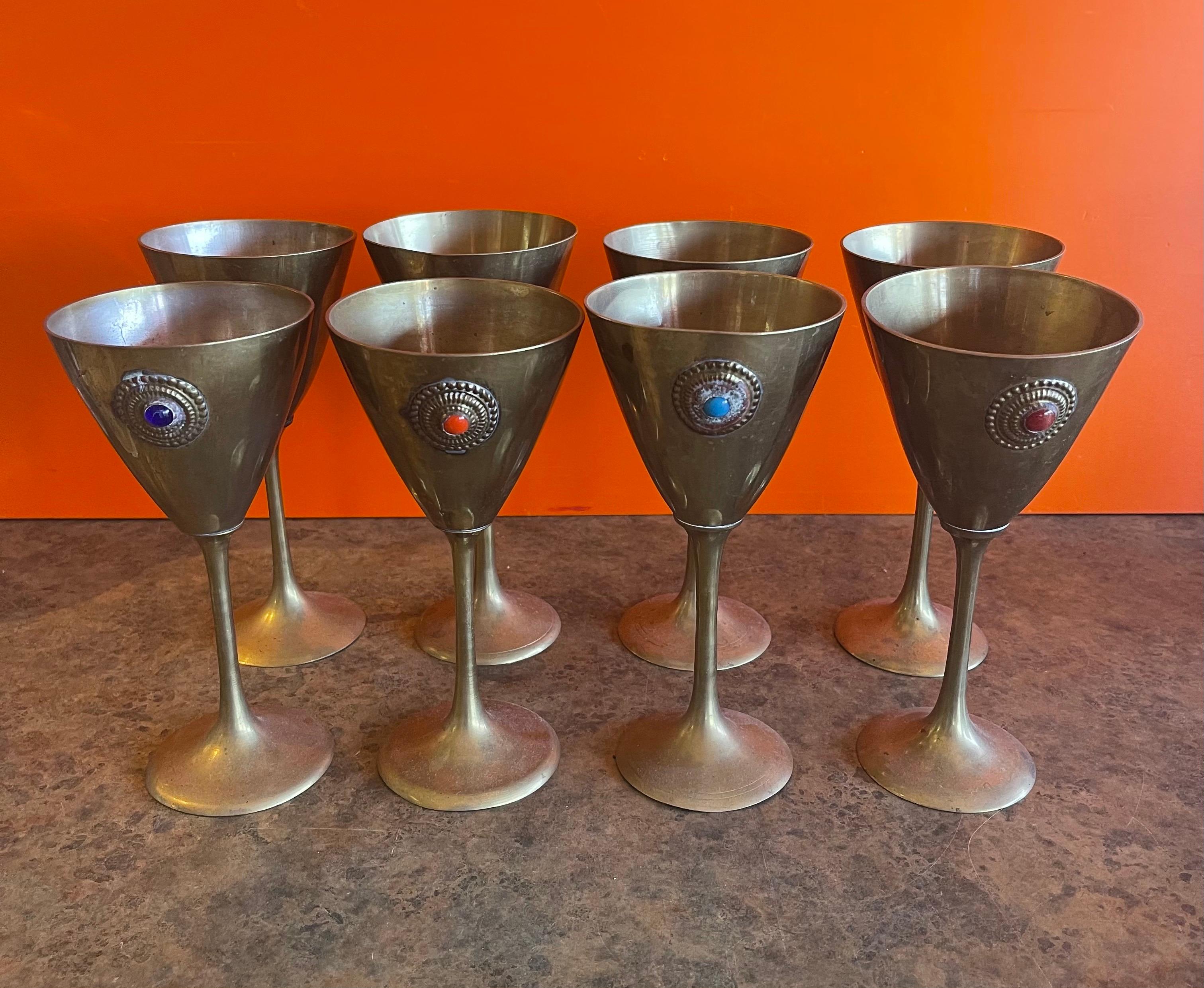Ensemble de huit gobelets à eau / vin en laiton avec accent en pierre colorée, vers les années 1970. Les gobelets contiennent 8 oz. de liquide et sont en très bon état. Chaque pièce mesure : 3,5