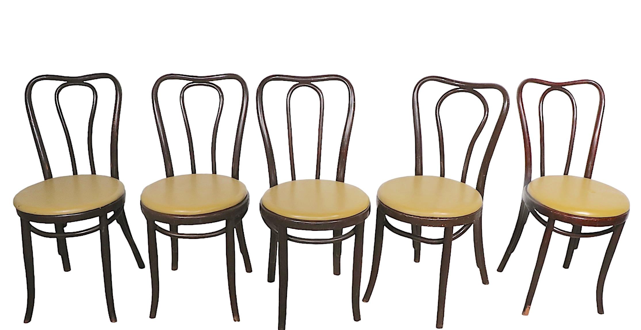 Classic set of eight cafe, dining, bistro chairs by Thonet. The chairs are in good original condition, structurally sound and sturdy however all show signs of age and use, notably chips to the front legs of two chairs, and general nick and bruises -