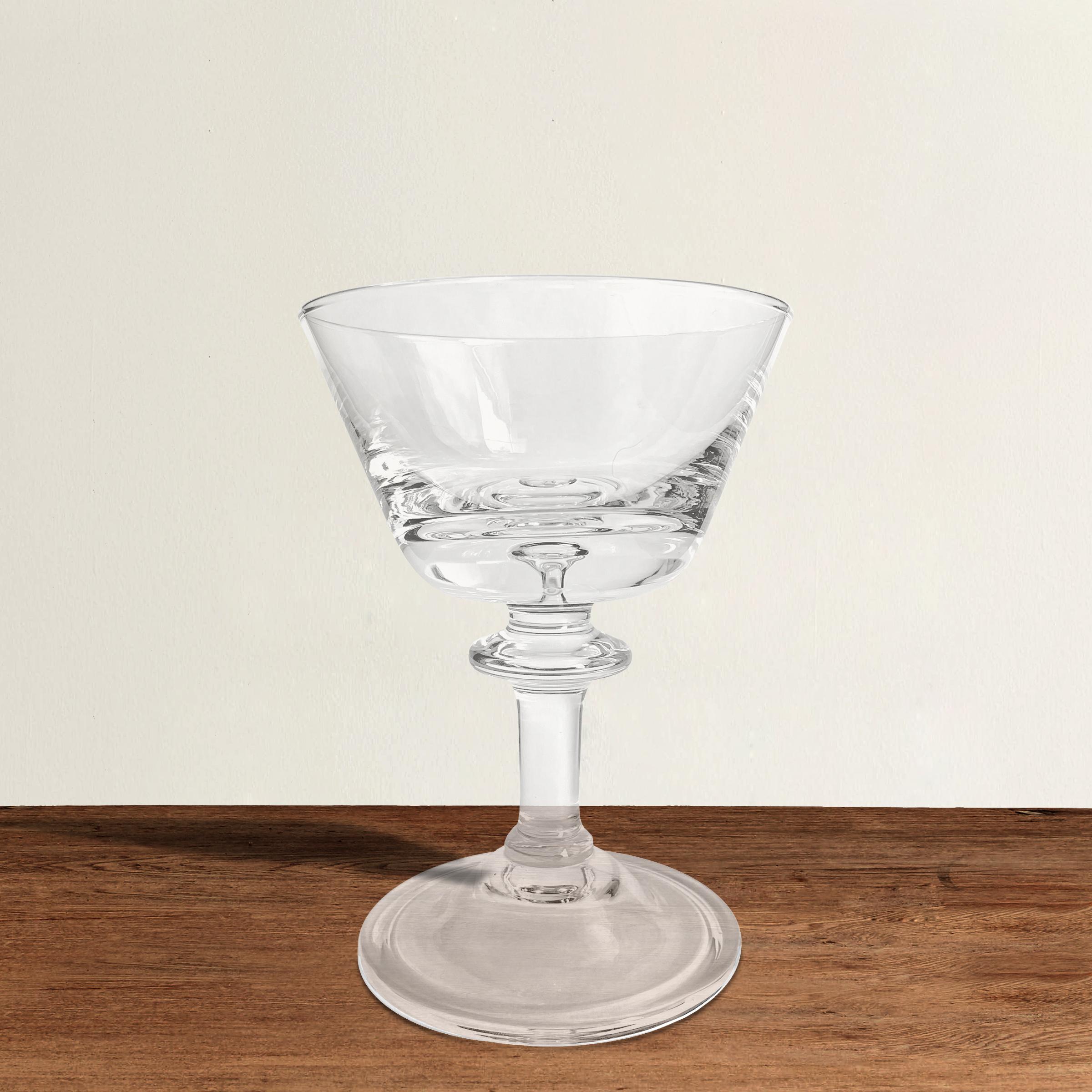 A wonderful set of eight vintage American blown crystal champagne coupes each with a captured bubble in the bottom of the bowl, and a rolled foot. Not just perfect for serving champagne or sparkling rosé at your next fête, but also a great size for