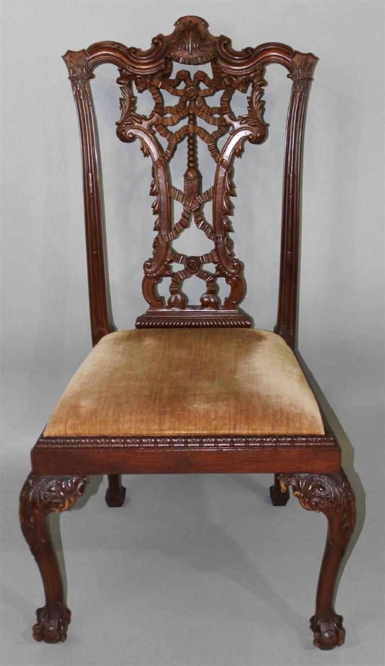 An outstanding set of eight carved mahogany Chippendale style ribbon back dining chairs with slip seats. Deep, rich carving.
Two arm, six side chairs.