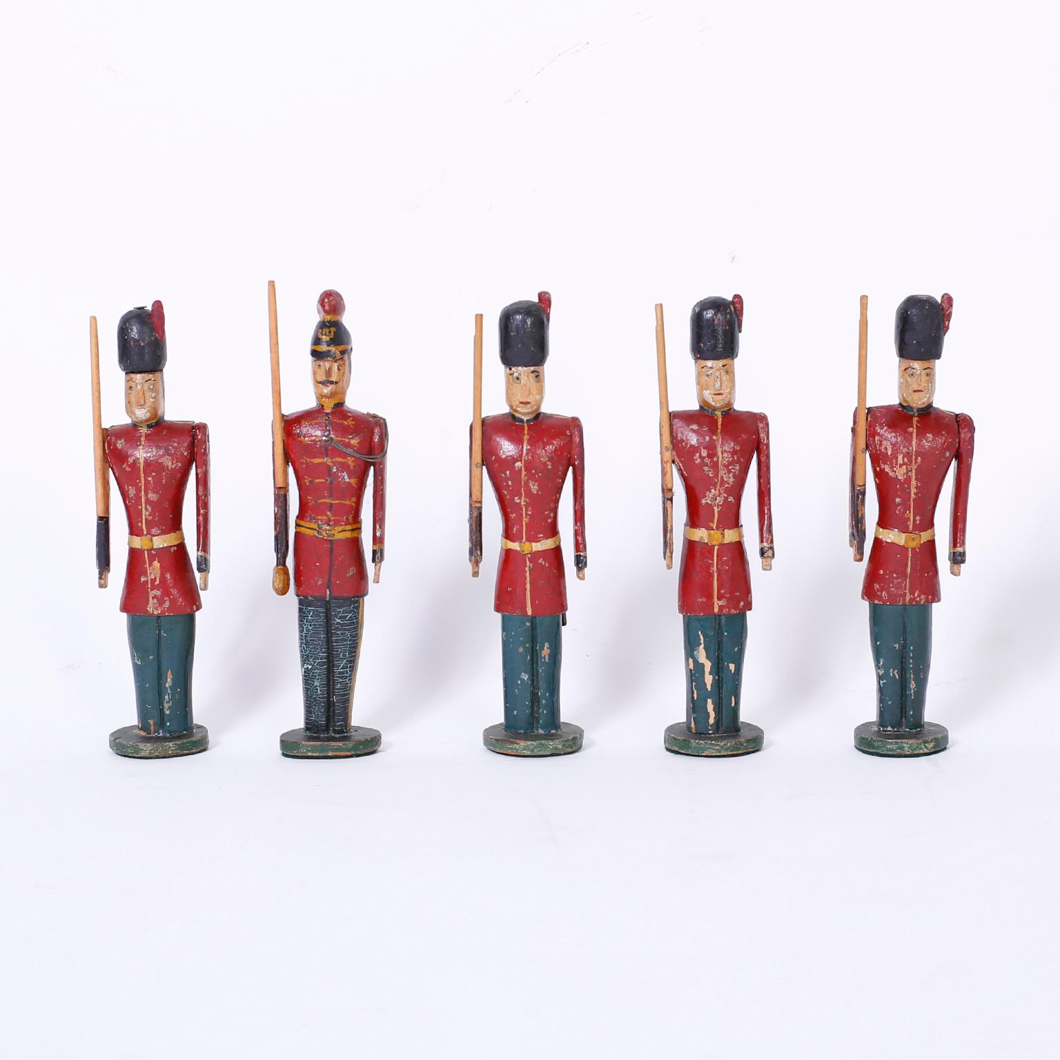 Eight charming antique carved wood figures displaying several versions of 19th century English military uniforms with diverse physical attributes. Original paint now aged to perfection.