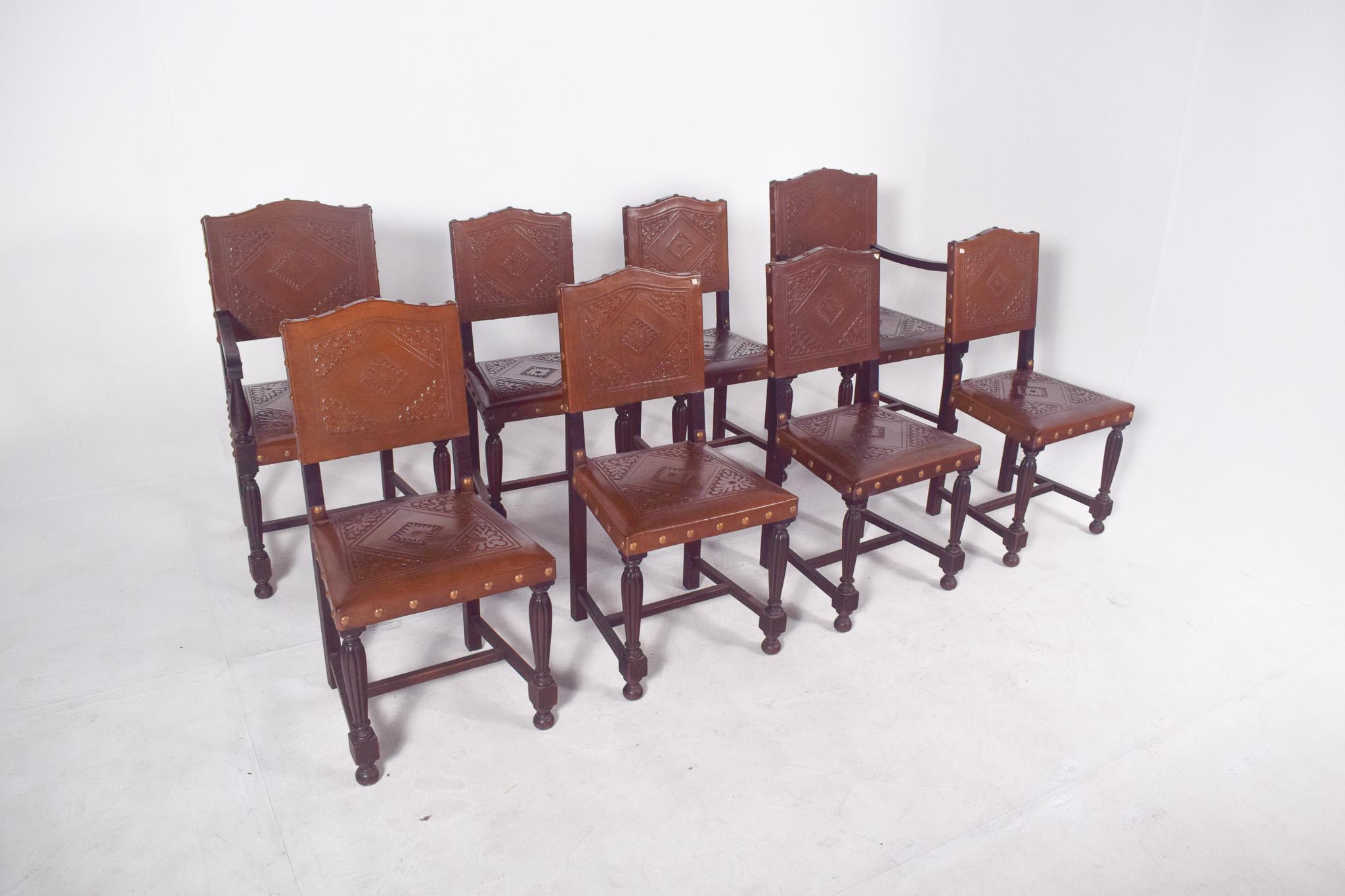 Conjunto de ocho sillas con respaldos y asientos de cuero tachonado. Dos de las sillas tienen reposabrazos, la estructura es de madera torneada y el asiento y el respaldo están tapizados en cuero envejecido con decoración en relieve. La piel tiene