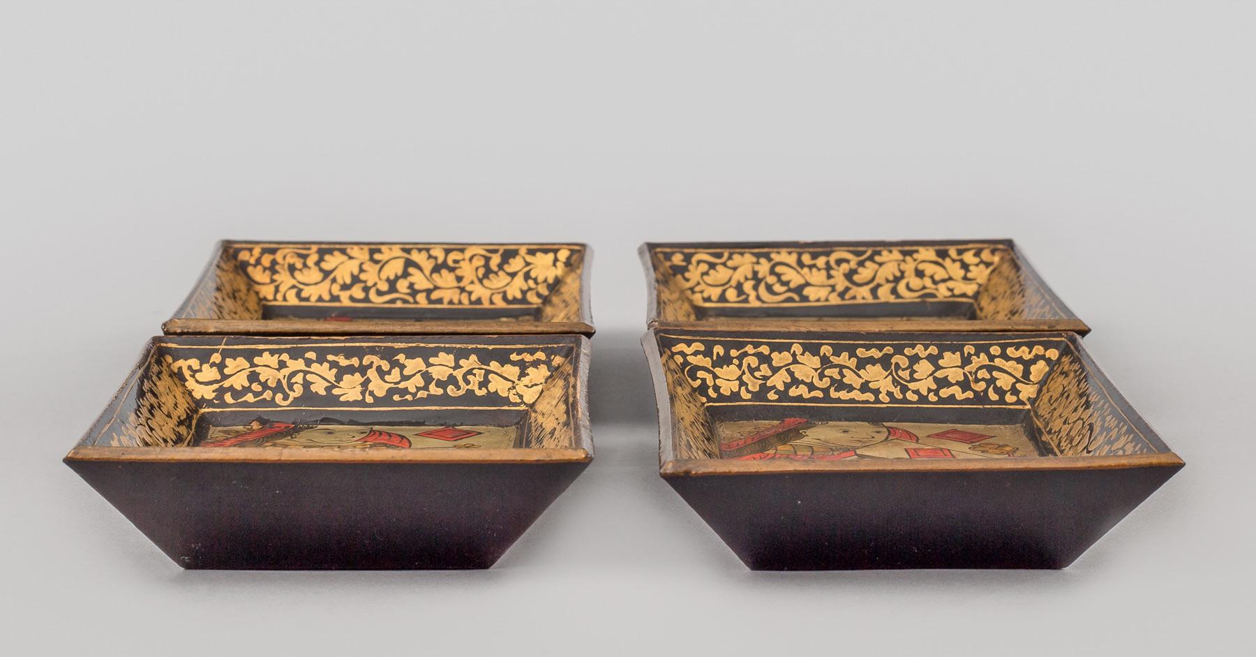 Set of eight Chinese Export Canton very small lacquered trays. Four depict the king and queen in red and gilded costumes against a black background; four depict figures in palace scenes with pagodas against a gilded and black background.