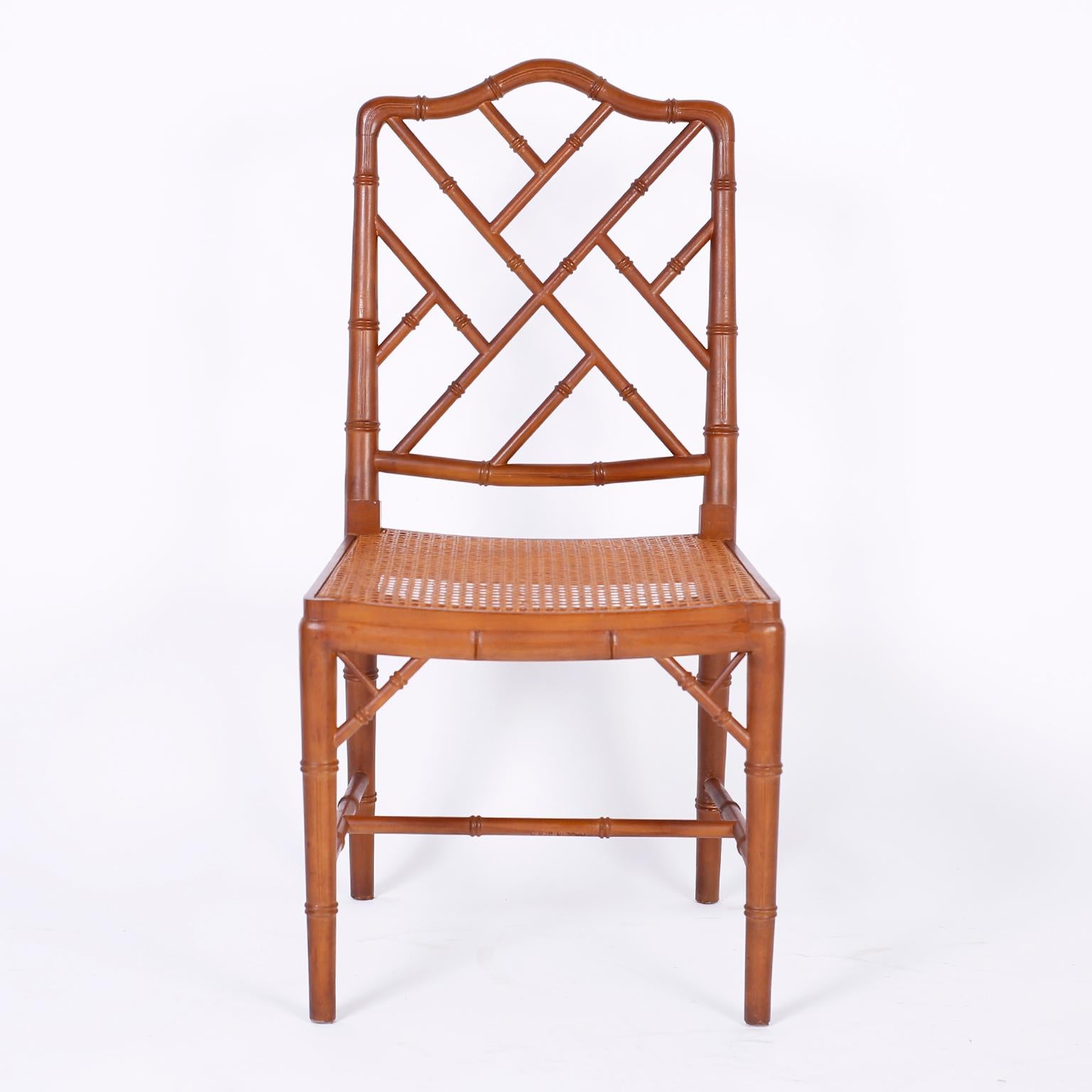 Set of eight faux bamboo fruitwood dining chairs, two arms and six sides, with Classic trellis backs and arms, caned seats, Asian style brackets and elegant tapered legs.

Armchairs measure: H 36.5, W 23, D 22, SH 16.5
Side chairs measure: H