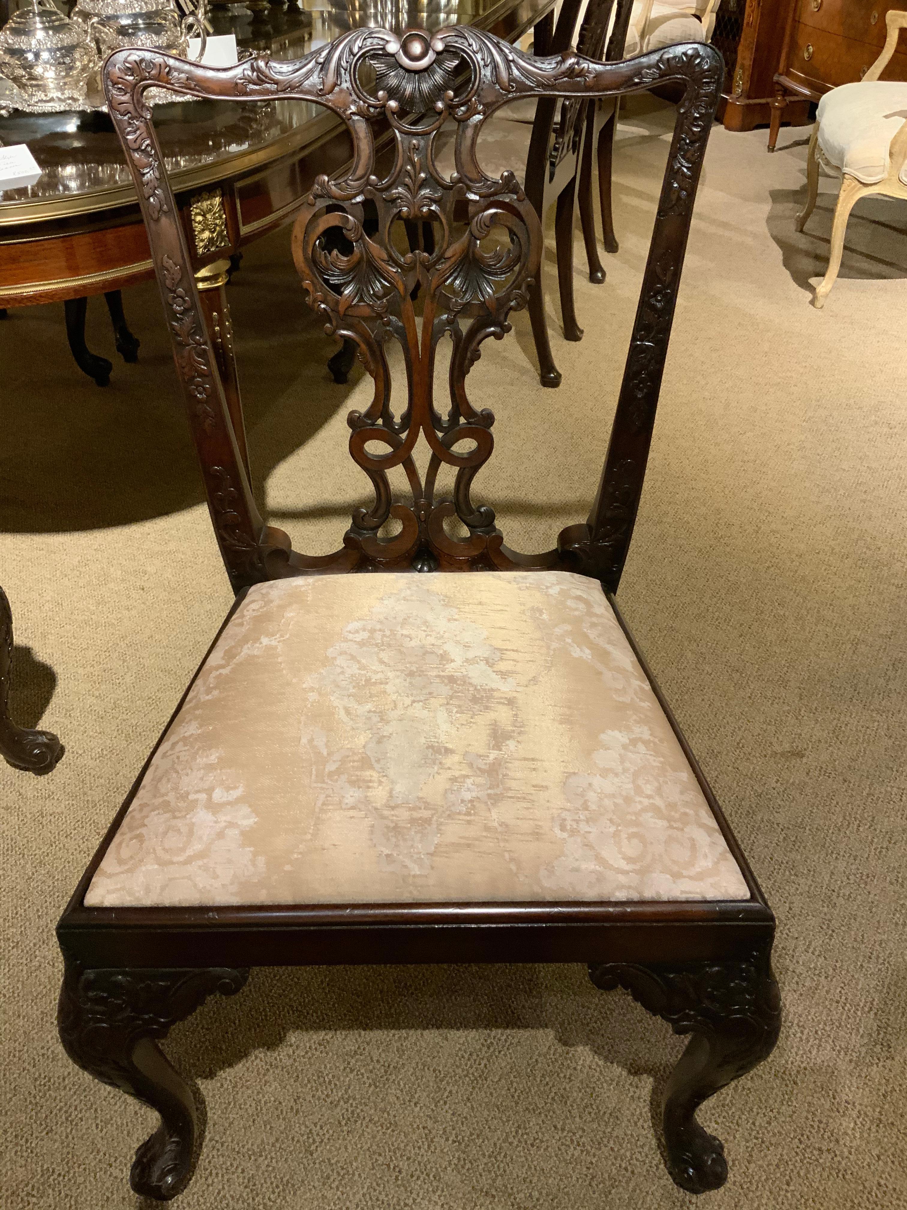 Richly carved frames with exquisite open work with shell and foliate designs on the
Back splat over padded and newly upholstered seats rising on cabriole legs ending in
Acanthus feet. Set is comprised of 2 arms and six sides.