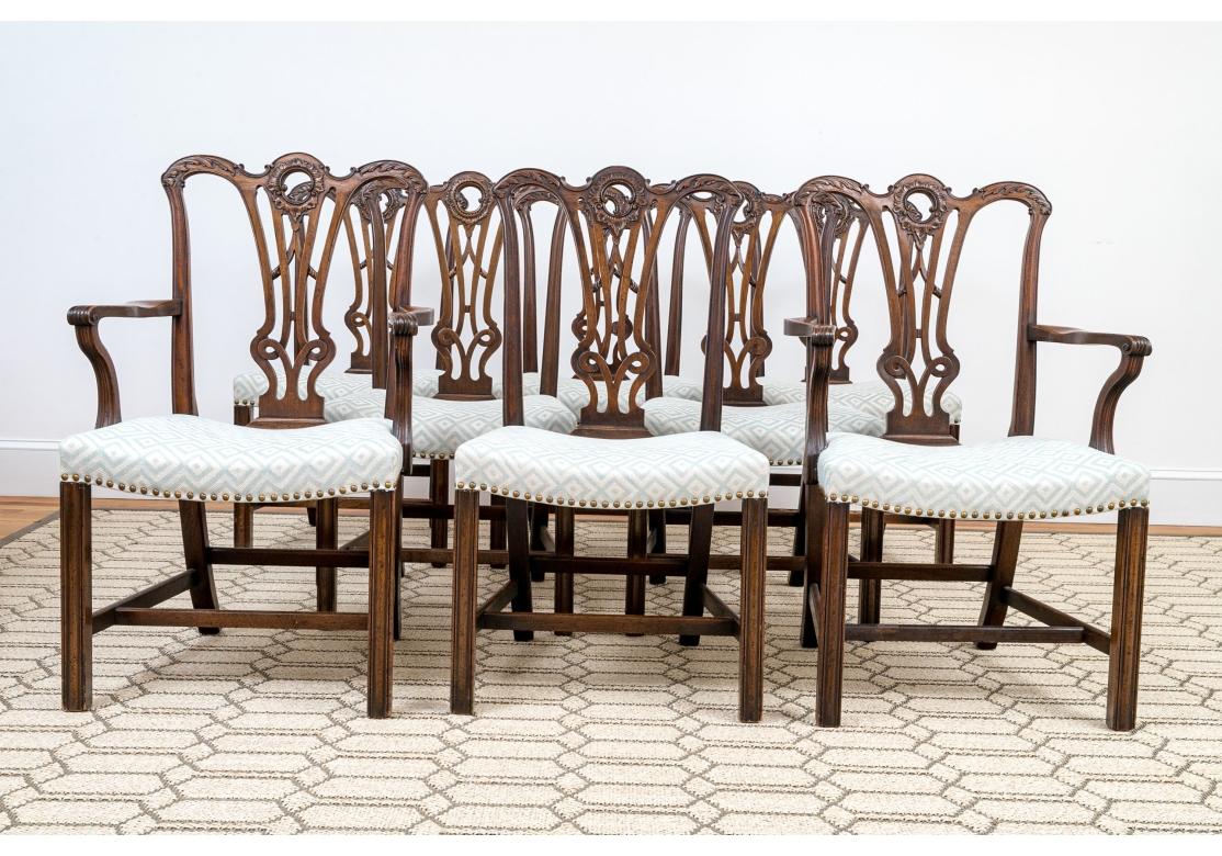 Excepcional juego de sillas de comedor con armazón de caoba maciza y hermosas tallas. Asientos tapizados a medida con remates de clavos de latón. Marcos bellamente tallados sobre patas achaflanadas con camilla en forma de H. Las tablillas traseras