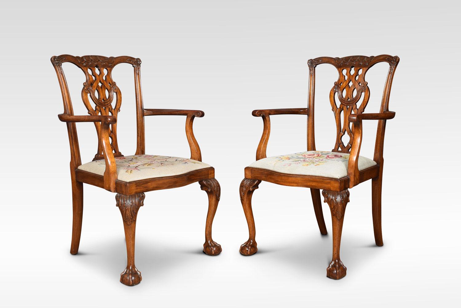 Set of eight mahogany dining chairs, the set consisting of two carvers and six single chairs. Each with yoked crest rail above a pierced splat with quatrefoil cut-outs over a drop-in needlepoint seat, each chair seat is different. All raised up on
