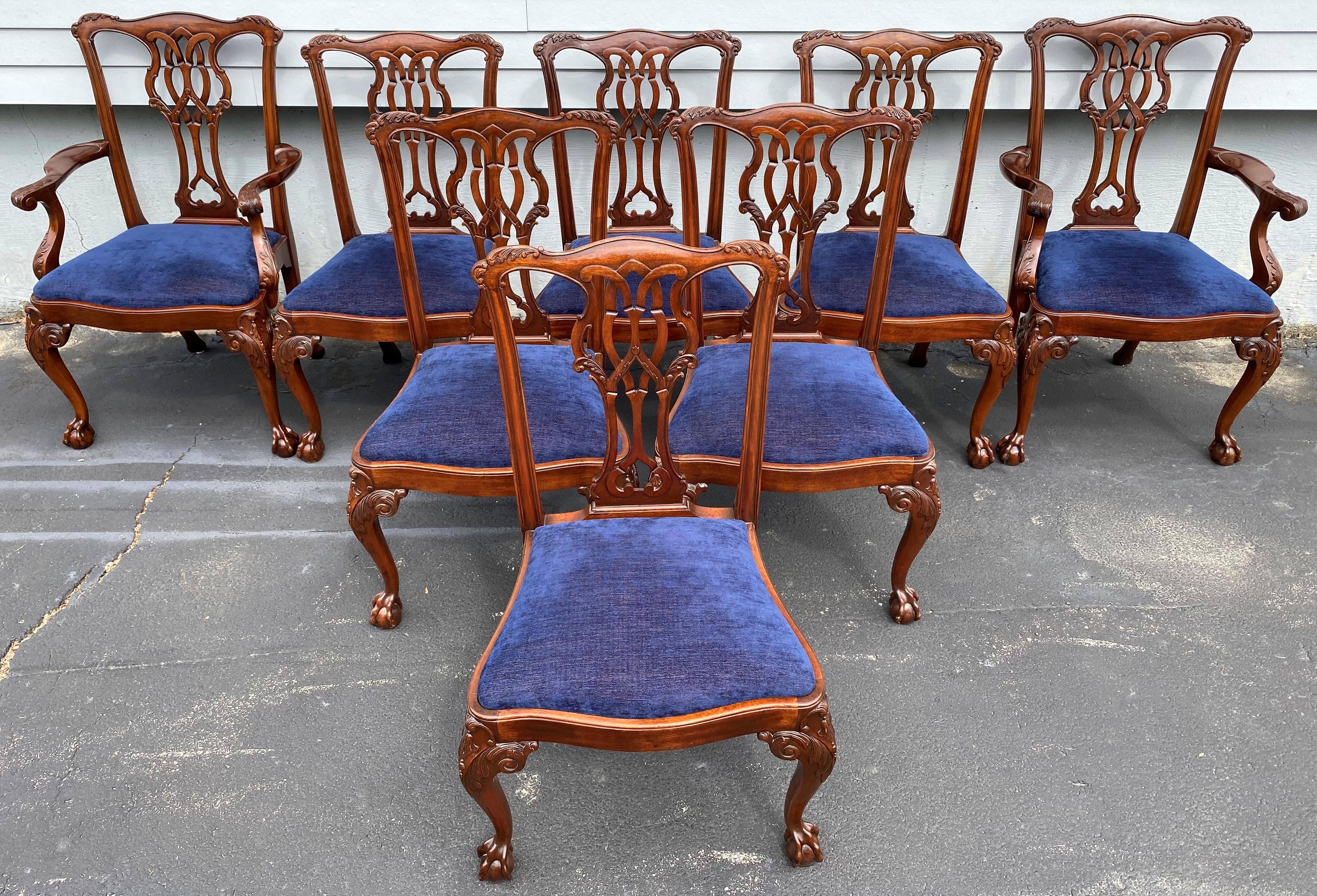 A fine solid set of eight Chippendale style mahogany dining chairs, including two arm chairs and six side chairs, with upholstered blue slip seats and beautifully detailed scroll carved crests, splats, and front cabriole legs with ball and claw