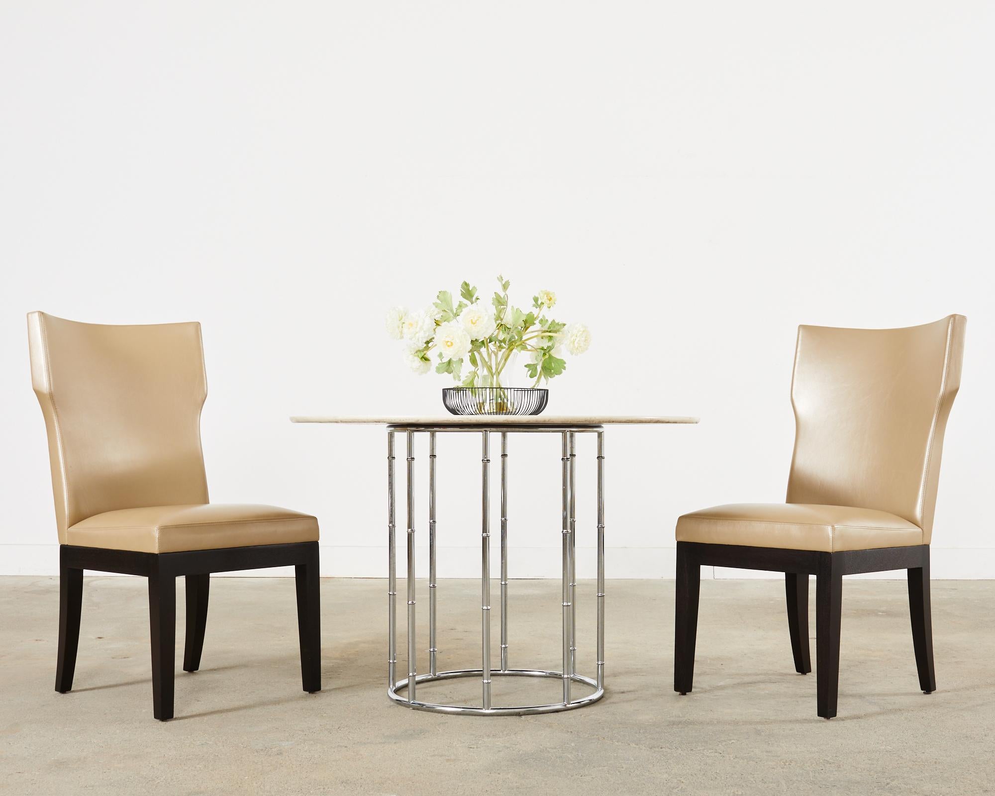 Sublime set of eight leather dining chairs designed by Christian Liaigre for Holly Hunt. The Barbuda chairs feature a distinctive frame with a curved back and subtle wings. The frames are black lacquer ebonized and finished in a metallic style