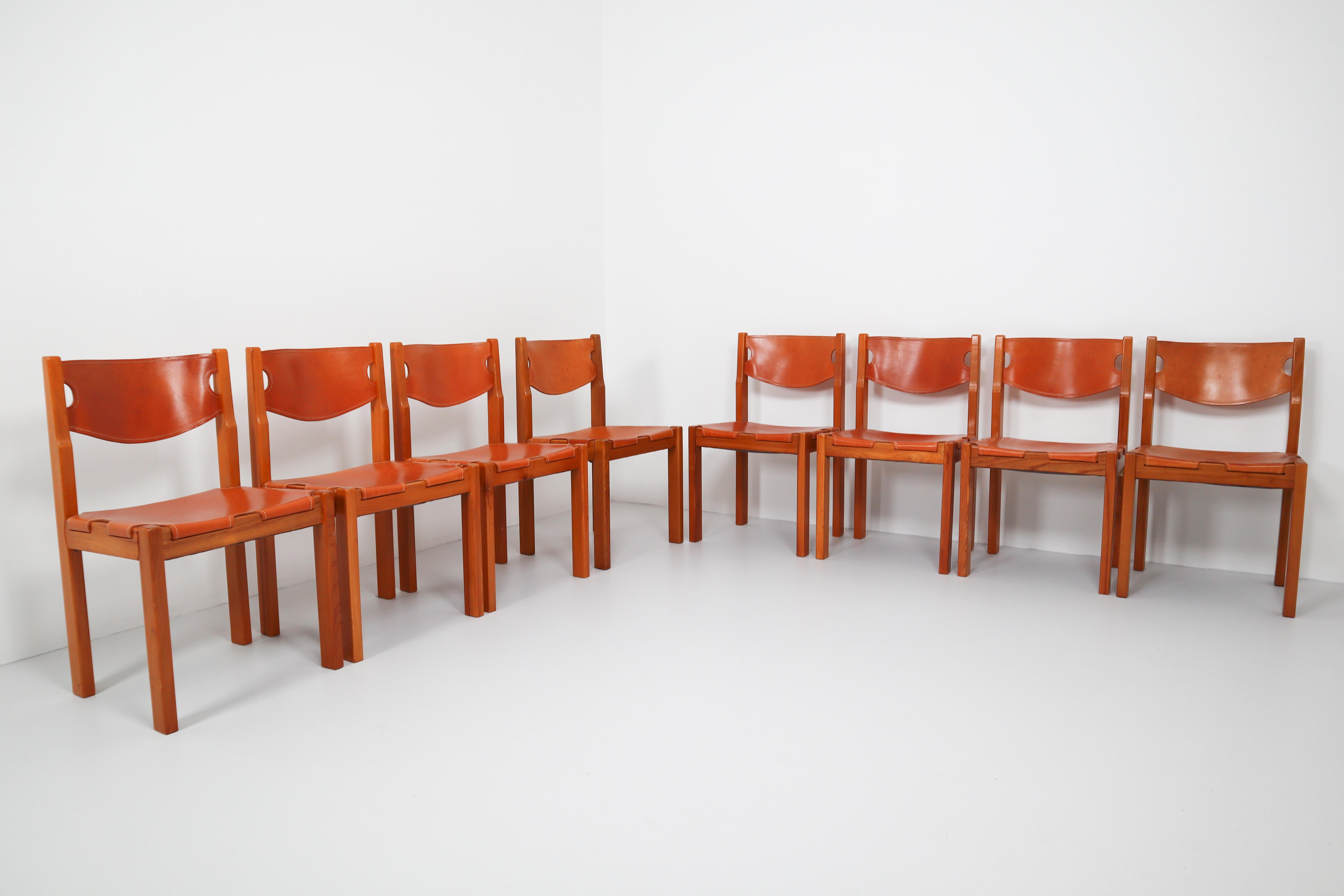 Set of eight cognac leather dining chairs in French pinewood. Cognac leather chairs from France, with a strong, architectural wooden frame. The cognac leather shows a very nice patina.