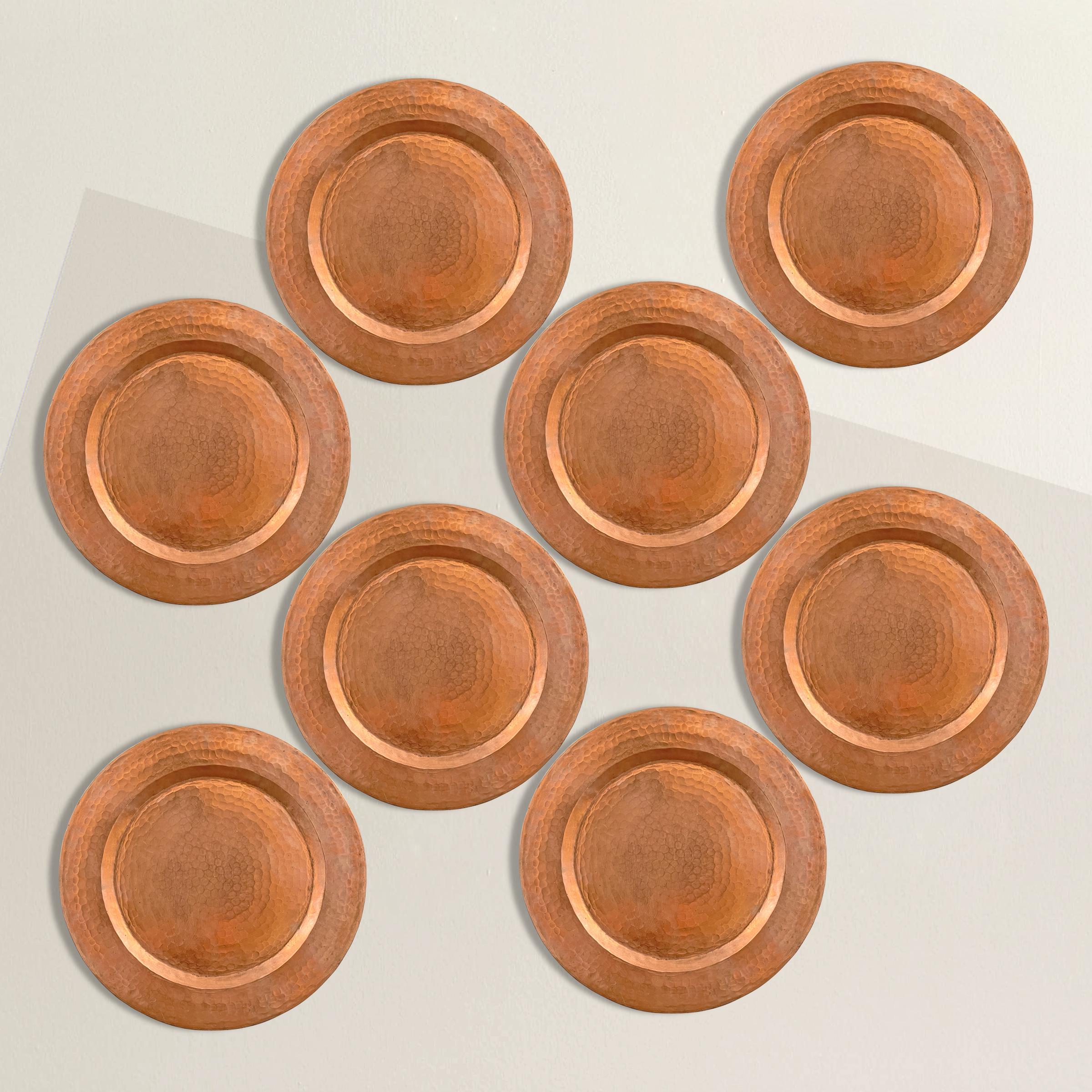 A chic set of eight hammered copper chargers with wide rims, perfect for setting your best table ever, but also useful under potted plants.