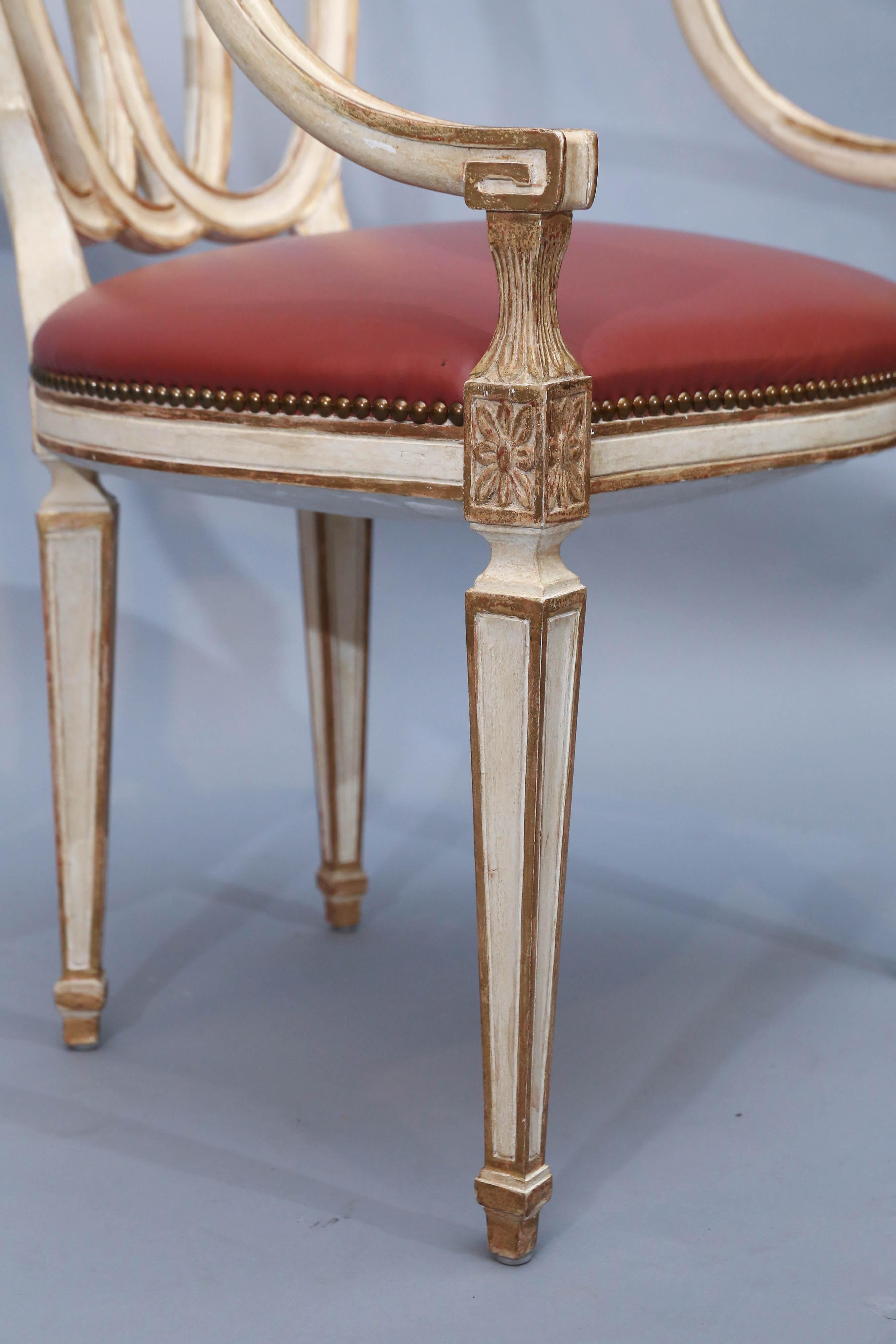 Set of eight Ribbon-back arm dining chairs feature tapered legs, front and back, rosettes on corner blocks with carved acanthus leaves below step-back arms.
Finish is an aged white with gold trim out-lining the fine details of chairs.
Step-back arms