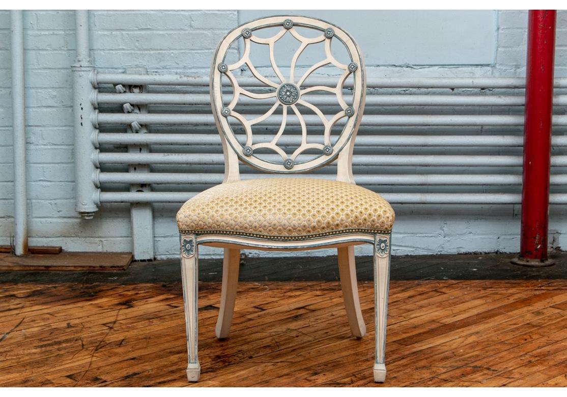 A notable set of eight web back chair in painted frames and custom raised chenille seat fabric. The chair paint in an Ivory tone with blue rosettes and outline. The chairs are upholstered in a champagne silk tone background with a raised Chenille