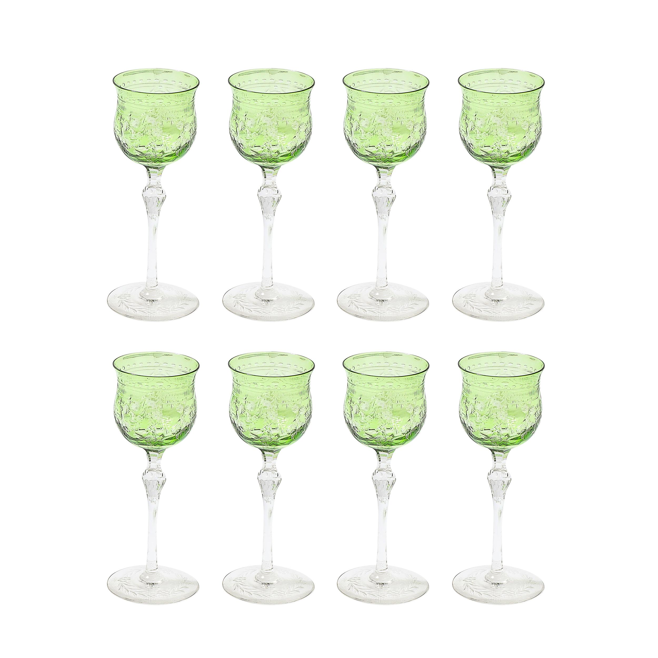 This striking Set of Eight Edwardian Cut Crystal Emerald Green & Transparent Glasses originates from Czechoslovakia, Circa 1915. They feature precisely rendered forms with ornate geometrically rendered natural detailing delineating the shapes and