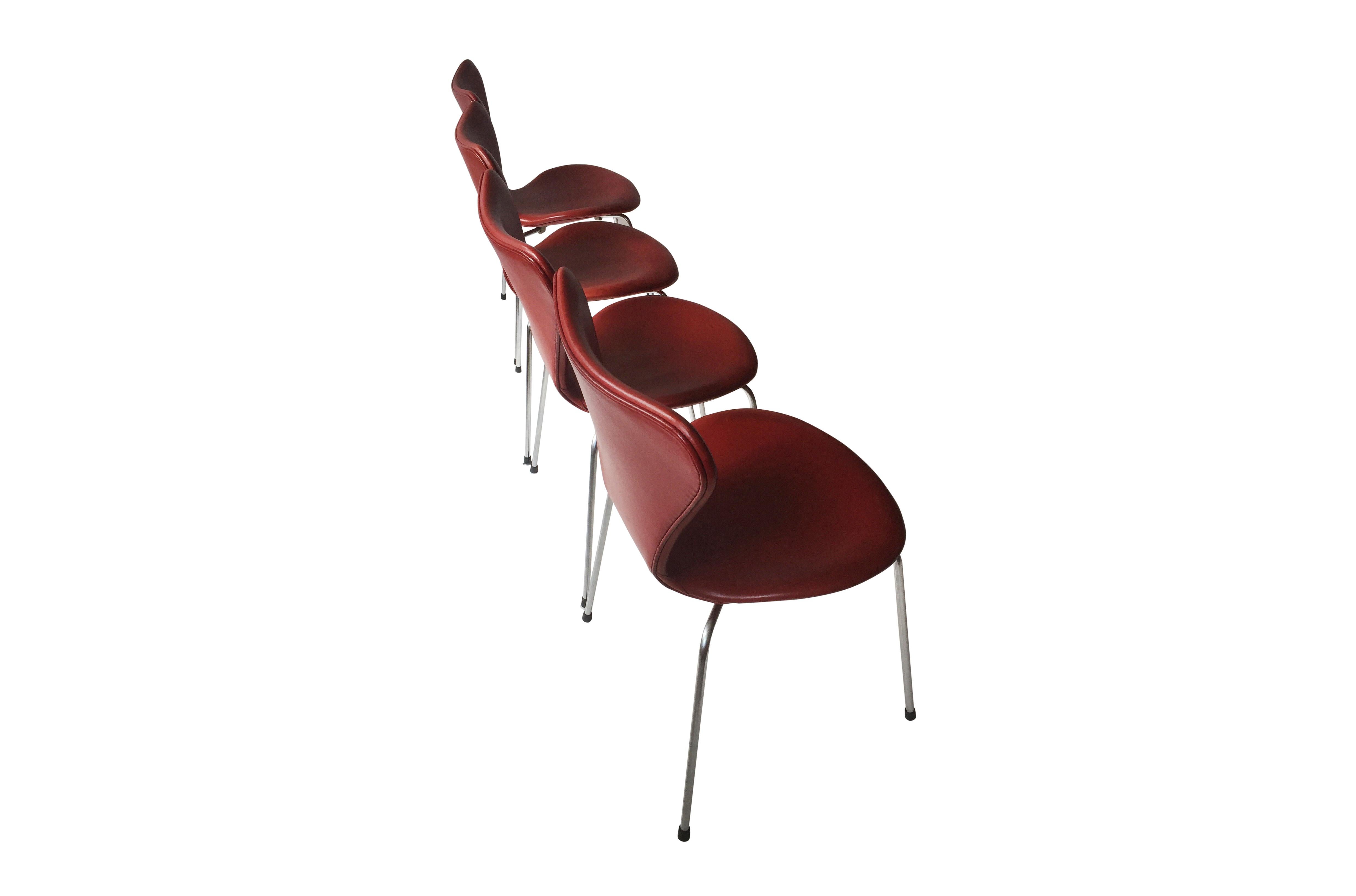 A set of 8 dining chairs, model 3107, designed by Arne Jacobsen in 1955, manufactured by Fritz Hansen. The chairs are in great condition, the Indian red leather is nice and warmly patinated. This Indian red leather is very rare to find. These