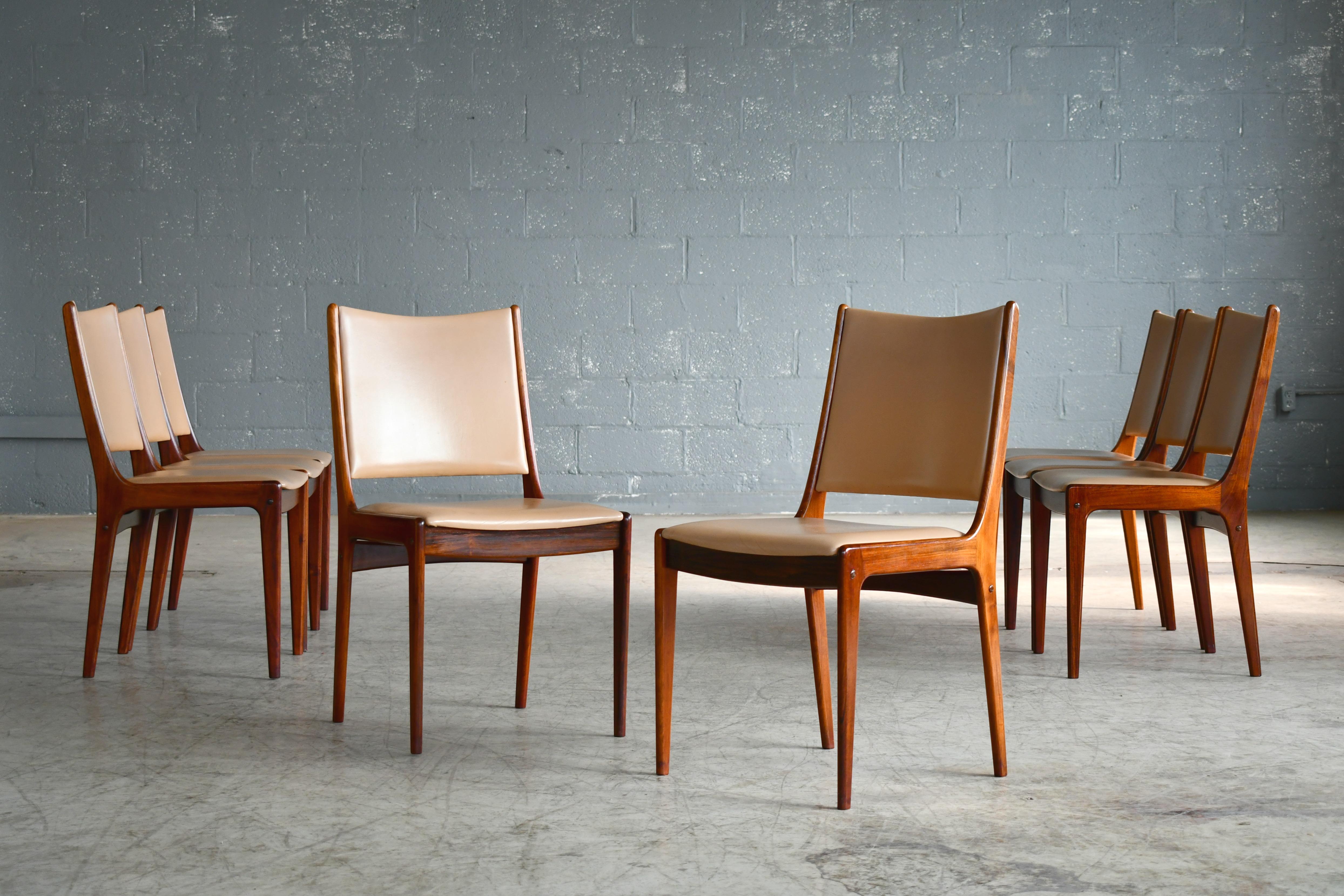Beautiful set of 8 dining chairs in solid rosewood with leather covered seat and backrest designed by Johs Andersen for Uldum in the late 1960s. Classic light elegant Danish design. Overall very good to near excellent condition with the wood showing