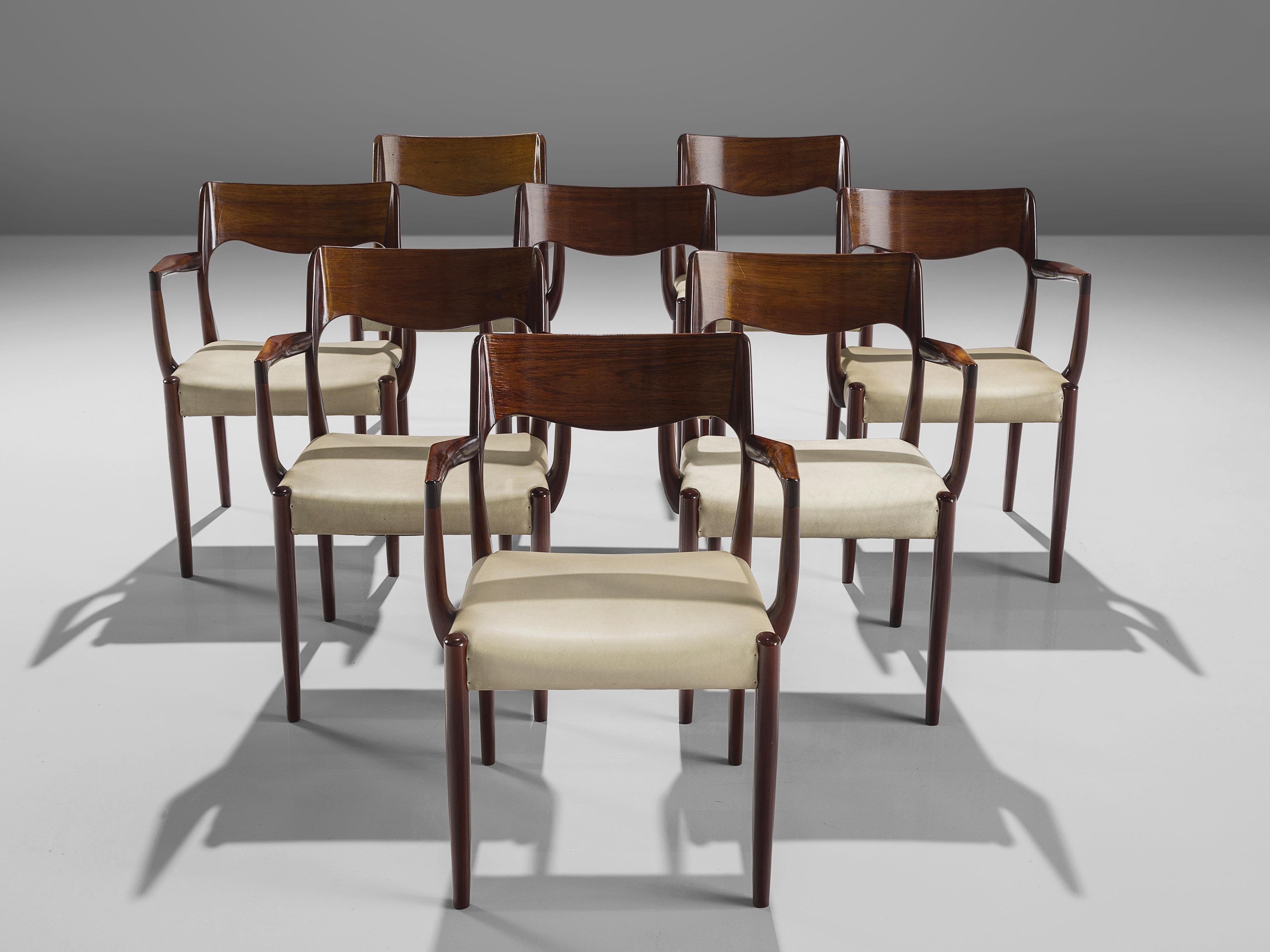 Set of eight armchairs, wood, faux leather upholstery, Denmark, 1950s.
 
This set of chairs shows subtle lines and beautiful curves. The way the backrest is designed with a dynamic line the chairs remind of the model 55 by Niels O. Møller. This