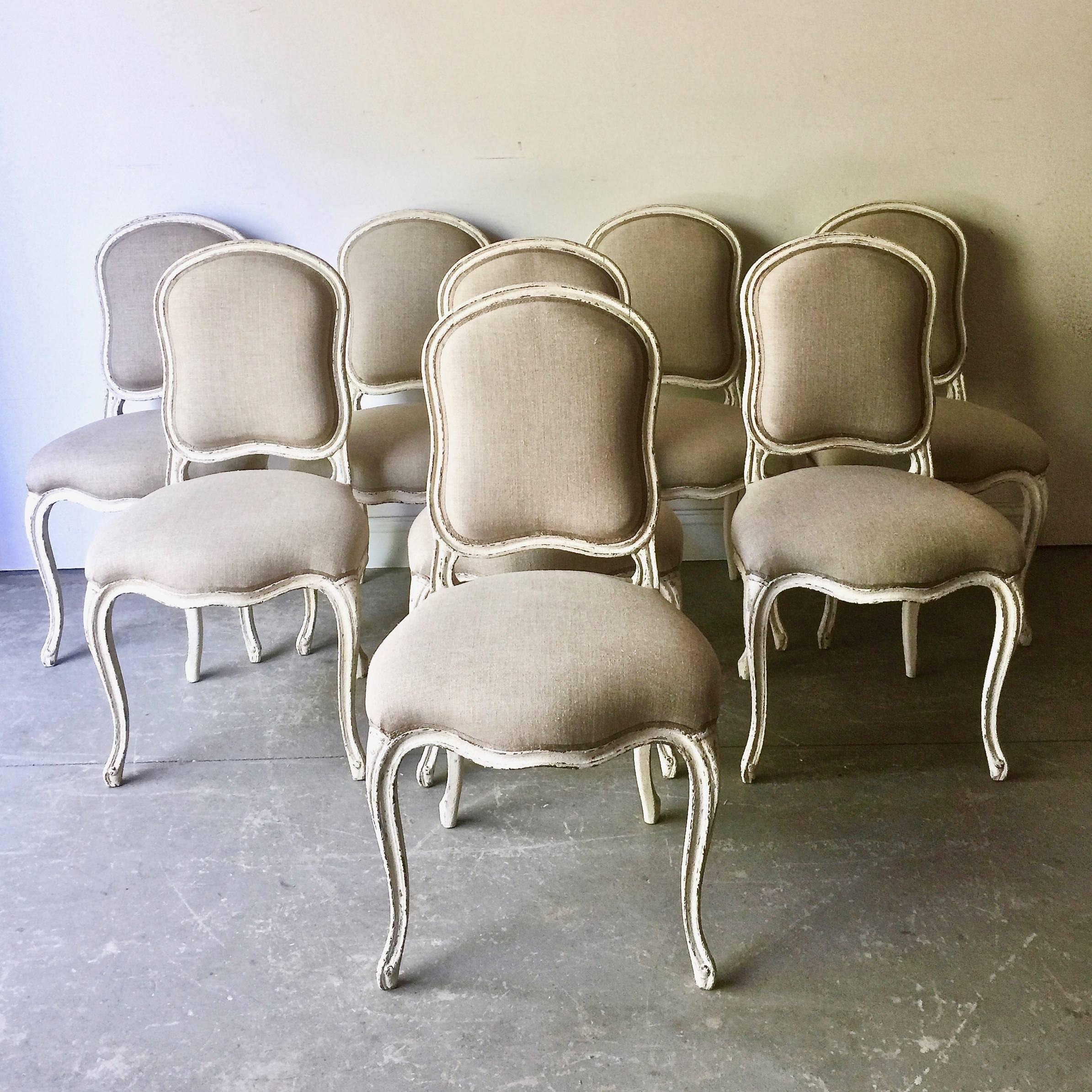 Set of eight decoratively carved French Louis XV style chairs, shaped back rail, scalloped frieze, raised on cabriole legs. Upholstered in linen and finished with the classic decorative cimp.
France, circa 1900.
 