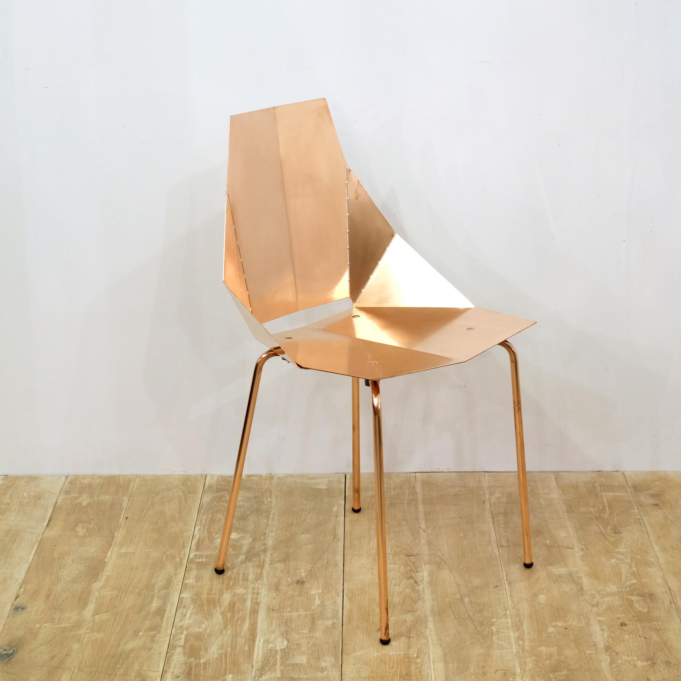 Set of 8 stunning designer chairs by Heals of London. Copper-plated angular ‘origami’ style shape, each with a bespoke deep blue velvet seat pad. Exuding quality, these chairs are surprisingly comfortable with a slight ‘give’ in the backrests. They